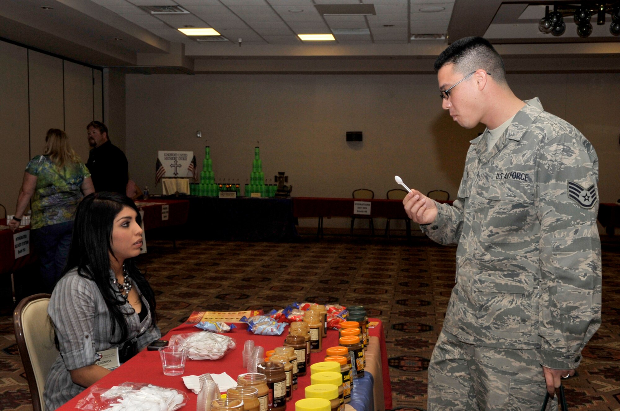 Staff Sgt. Eric Parks, 27th Special Operations Areomedical Dental Squadron, samples  peanut butter from Veronic Hernandez, who works at Sunland Peanut Farm, during the Discover Home Fair at The Landing Zone, April 30. The fair provided Airmen, their families and others the opportunity Airmen to gather information about areas surrounding Cannon to explore New Mexico and West Texas during the summer. (U.S. Air Force photo by Staff Sgt. Heather R. Redman)
