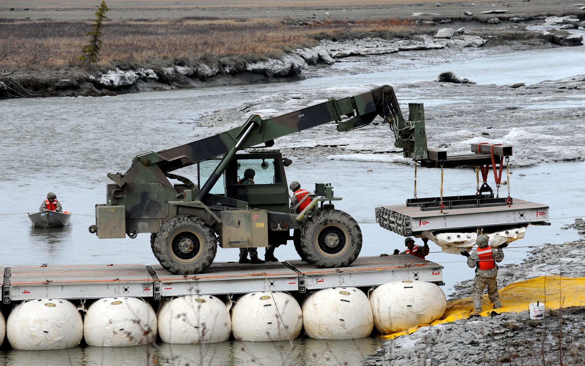 Soldiers from the 84th Engineer Support Company, 6th Engineer Battalion, maneuvers the last section of Lightweight Modular Causeway System into place at Fort Richardson, Alaska, April 28. The LMCS is a hybrid fixed bridging system and floating causeway system.  Originally designed for vessel-to-shore bridging applications, it has proven ideally suited for wet-gap crossing solutions.  The load capacity is 70 tons. Here it is being used to respond during Arctic Edge 2010 as an earthquake recovery tool. (U.S. Air Force photo/Staff Sgt. Brian Ferguson)