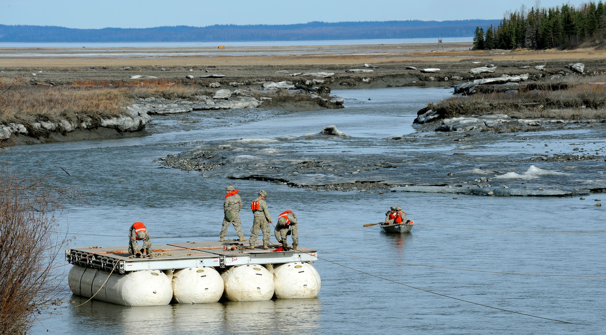 Soldiers from the 84th Engineer Support Company, 6th Engineer Battalion, construct a Lightweight Modular Causeway System during testing at Fort Richardson, Alaska, April 28. The LMCS is a hybrid fixed bridging system and floating causeway system.  Originally designed for vessel-to-shore bridging applications, it has proven ideally suited for wet-gap crossing solutions.  The load capacity is 70 tons. Here it is being used to respond during Arctic Edge 2010 as an earthquake recovery tool. (U.S. Air Force photo/Staff Sgt. Brian Ferguson)