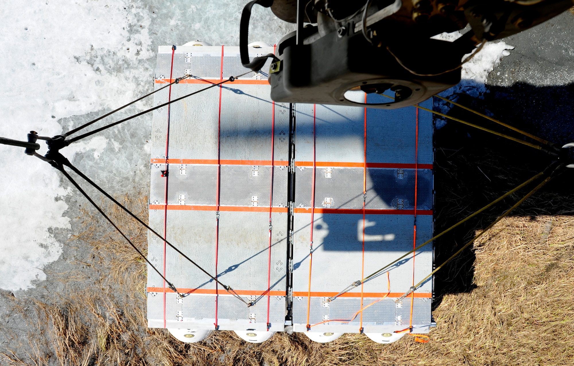 A piece of Lightweight Modular Causeway System is lowered to the ground during testing at Fort Richardson, Alaska, April 27. The LMCS is a hybrid fixed bridging system and floating causeway system.  Originally designed for vessel-to-shore bridging applications, it has proven ideally suited for wet-gap crossing solutions.  The load capacity is 70 tons. Here it is being used to respond during Arctic Edge 2010 as an earthquake recovery tool. (U.S. Air Force photo/Staff Sgt. Brian Ferguson)