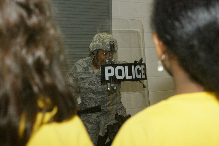 Staff Sgt. Dominique James, 94th Security Forces Squadron security response team member, demonstrates the wear and use of riot control gear during the student space team visit from Russell Elementary School March 12.  (U.S. Air Force photo/Don Peek)