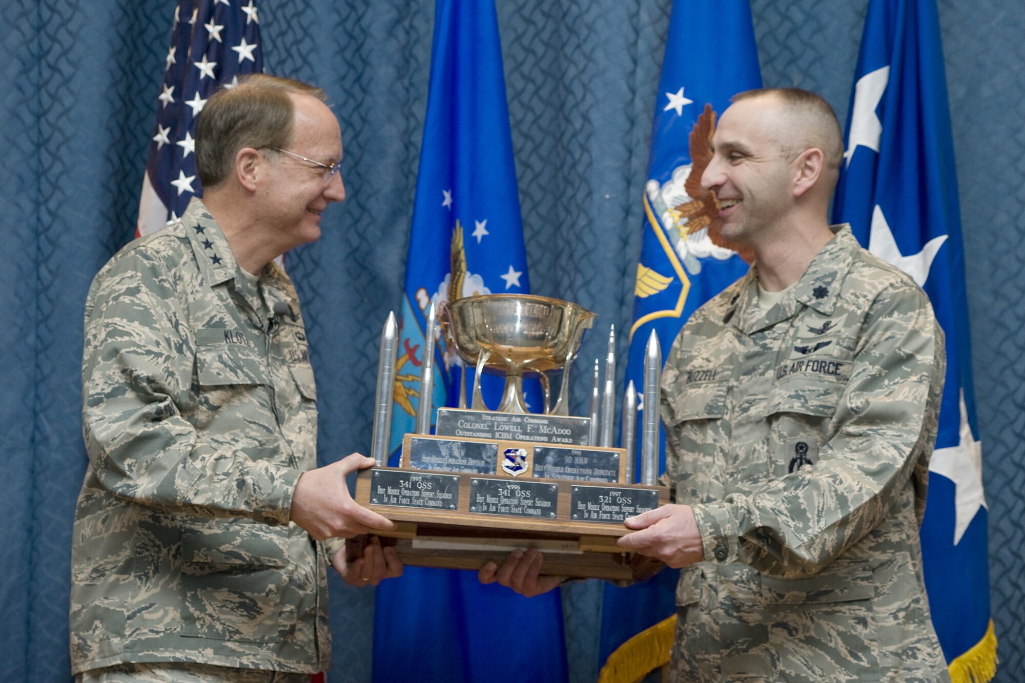 Lt. Gen. Frank Klotz, Air Force Global Strike Command commander, presents the Colonel Lowell F. McAdoo Trophy to Lt. Col. Lloyd Buzzell, 341st Operations Support Squadron commander April 21. The award is presented annually to recognize the best overall ICBM OSS. (U.S. Air Force photo/Beau Wade)