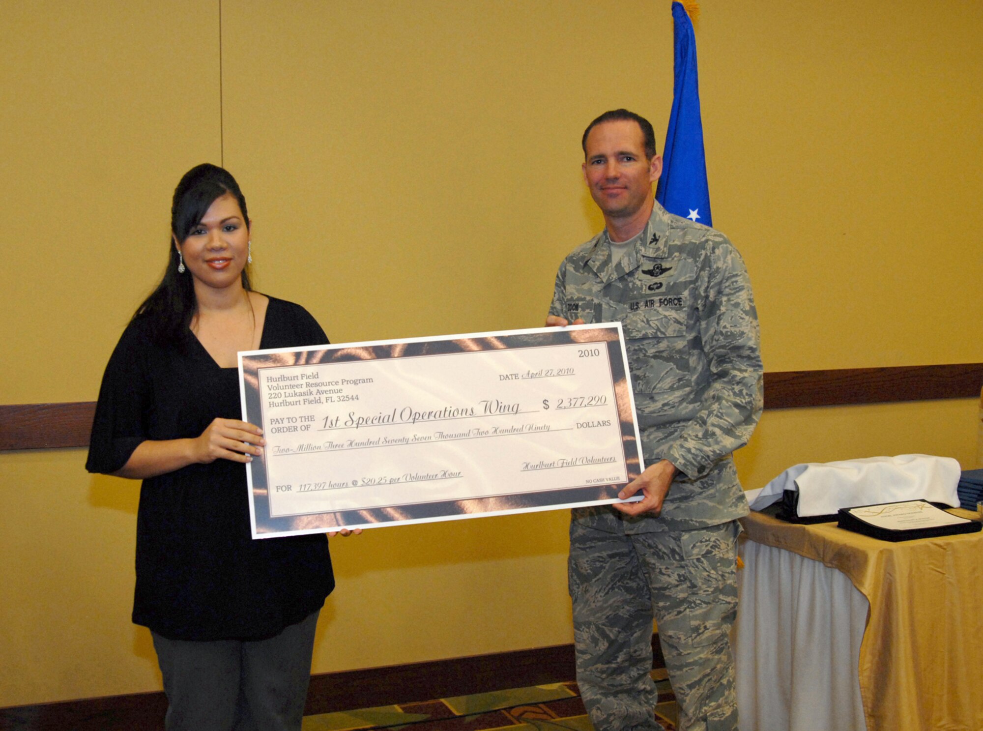 Ruthy Srun, Airman & Family Readiness Center volunteer coordinator, presents a check to U. S. Air Force Col. Daniel Zook, 1st Special Operations Wing vice commander, for the amount of money volunteers saved Hulburt Field in 2009 during the Hurlburt Field Volunteer Recognition Ceremony, Hurlburt Field, Fla., April 27, 2010.  (DoD photo by U. S. Air Force Staff Sgt. Orly N. Tyrell/Released)