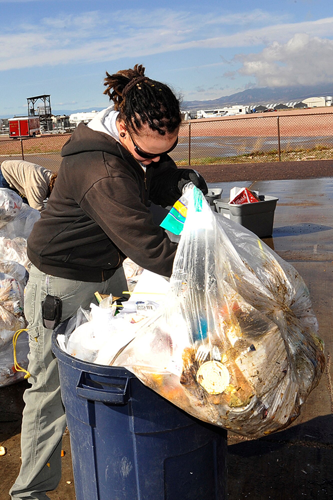 Angela Comer, an environmental consultant with RGI, digs through trash April 22 from Building 2 on Peterson Air Force Base. Ms. Comer is looking for recyclable material that could have been put in recycling bins. The trash audit helps the 21st Civil Engineer Squadron design recycling programs for individual buildings, which might include adding recycling containers inside offices and recycling bins outside. The audits help Peterson AFB reach its goal of recycling 50 percent of its material. (Editor’s Note: Photo by Marisa Aragon, 16, who shadowed 21st Space Wing photographer Rob Bussard on April 22 for "Bring Your Child to Work Day." Miss Aragon is a high school student and is enrolled in a photography class.)