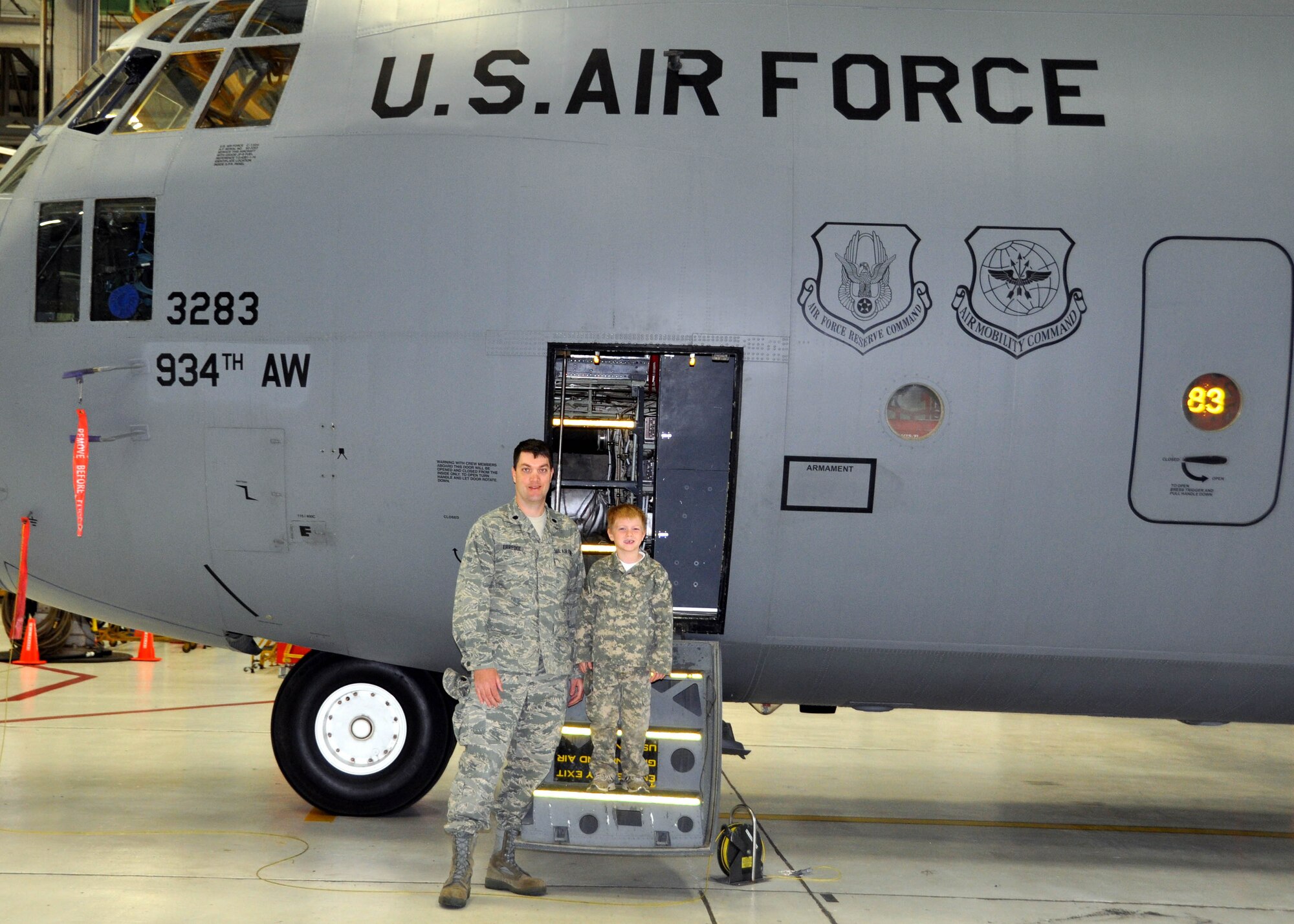 Caden Erredge, 6, and his dad, Lt. Col. Richard Erredge, 934th Communications Flight, pose for a photo outside a C-130 Hercules aircraft at the 934th Airlift Wing?s first Take Your Child To Work Day? April 29. 