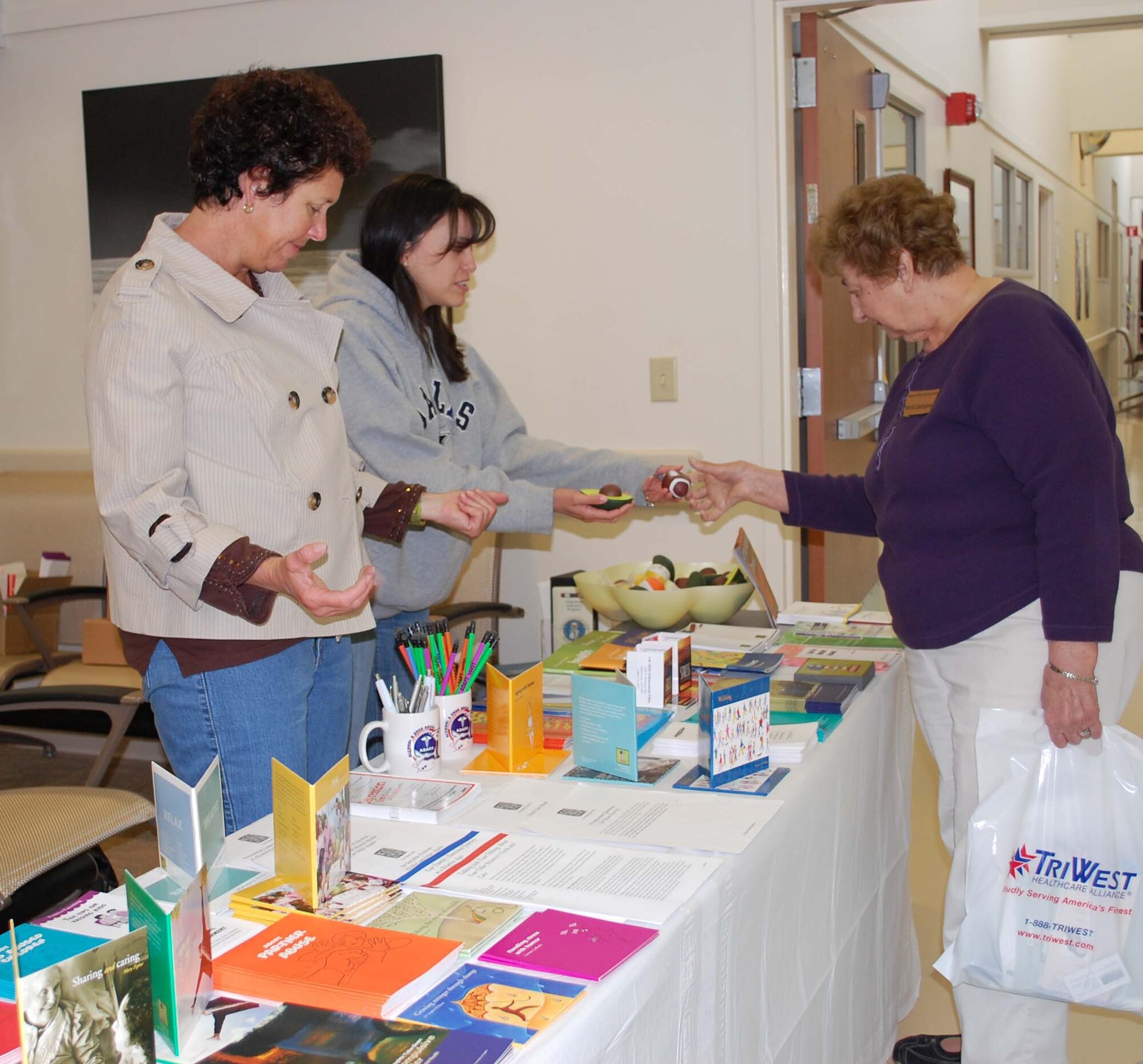 Melissa Laferriere, mental health technician, offers Aurelia Cunningham a choice of stress relief squeeze items during the Malmstrom Clinic's events honoring retirees April 24. Susanna Bower,family advocacy program assistant, is also pictured. (U.S. Air Force photo/Valerie Mullett)
