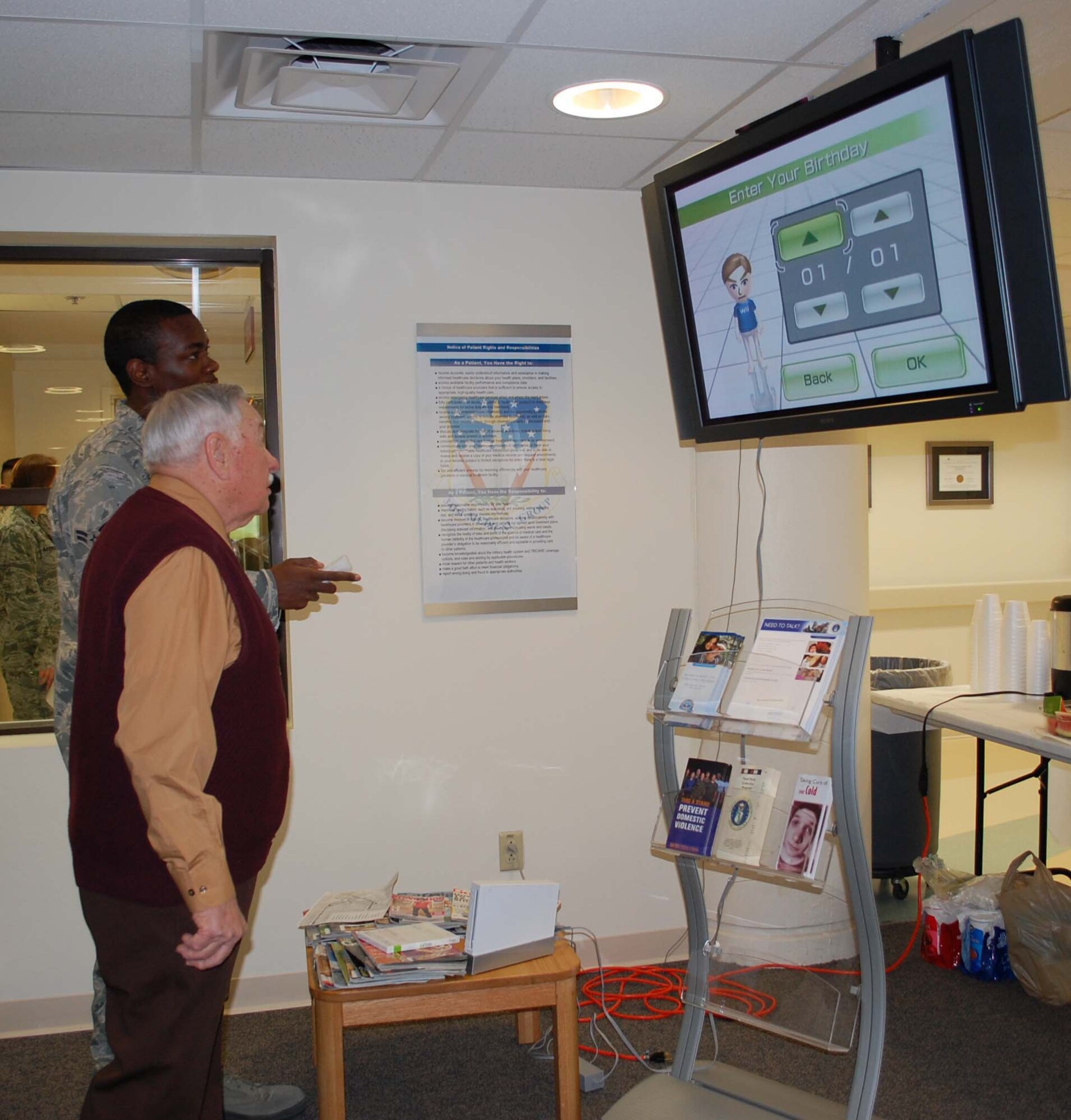 Airman 1st Class Ryan McCray, medical records technician, enters information into the WiiFit machine for retiree Herman Wittman to test his body mass index. At 89 years old, Mr. Wittman also participated in the formal retreat ceremony, in full Army dress uniform, April 23. (U.S. Air Force photo/Valerie Mullett)