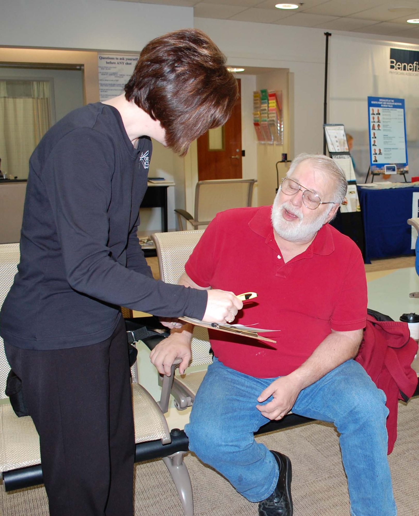 Stacy Allen from Benefis Healthcare, goes over some paperwork with retiree Jim Nys during Retiree Appreciation events at the Malmstrom Clinic April 24. (U.S. Air Force photo/Valerie Mullett)