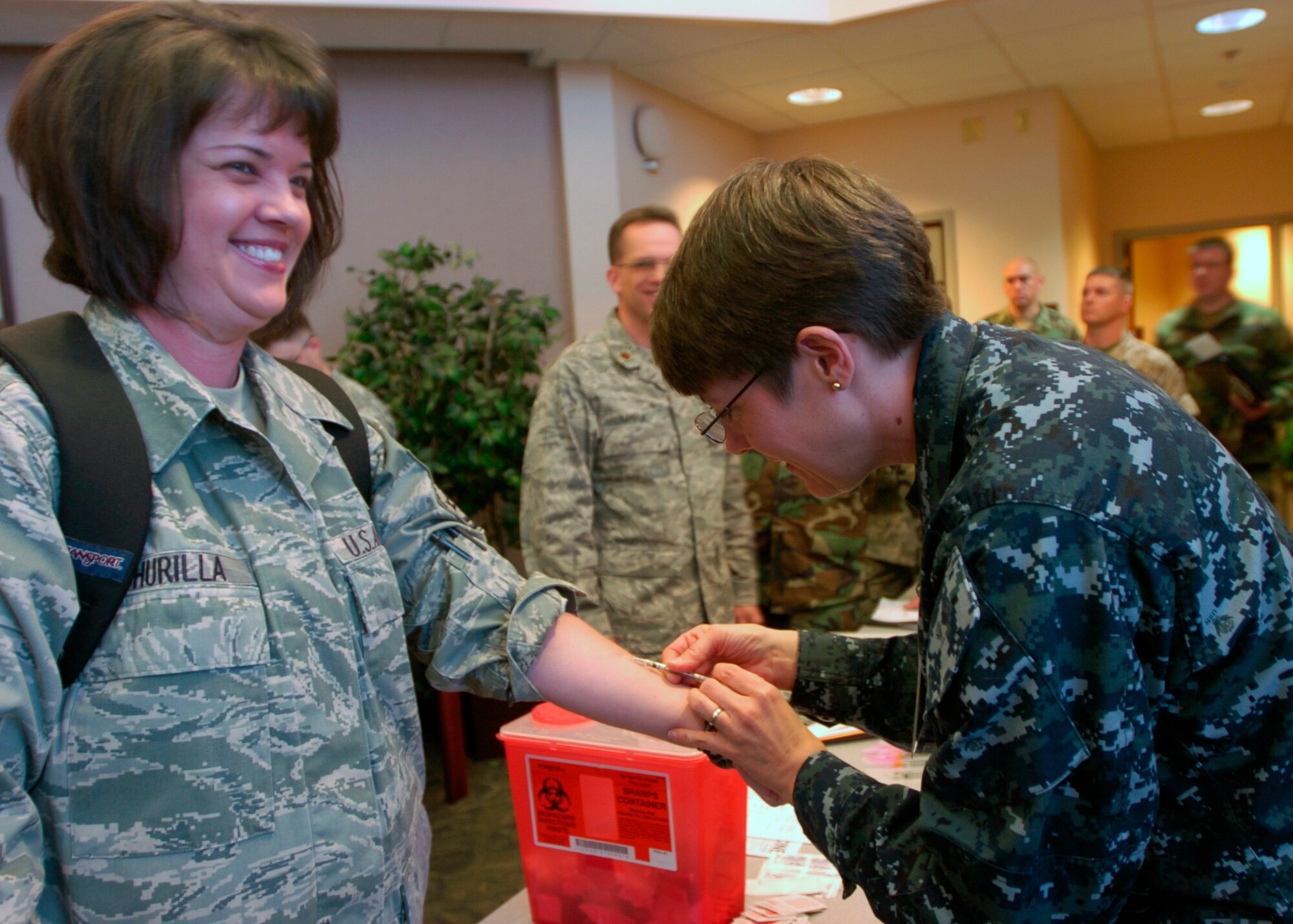 ELMENDORF AIR FORCE BASE, Alaska -- Senior Master Sgt. Julie Churilla, 1st Air Force, left, receives the H1N1 flu vaccination from Chief Petty Officer Jill S. Smith, Joint Task Force Alaska, inside the Alaskan Command Headquarters April 27.   Medical screening, including vaccinations, is just one part of the in-processing brief participants underwent. Arctic Edge 10 is an exercise to allow federal, state and local authorities to work together during a natural disaster training situation, prompting and interagency response. (U.S. Army photo by SPC Armando Limon)