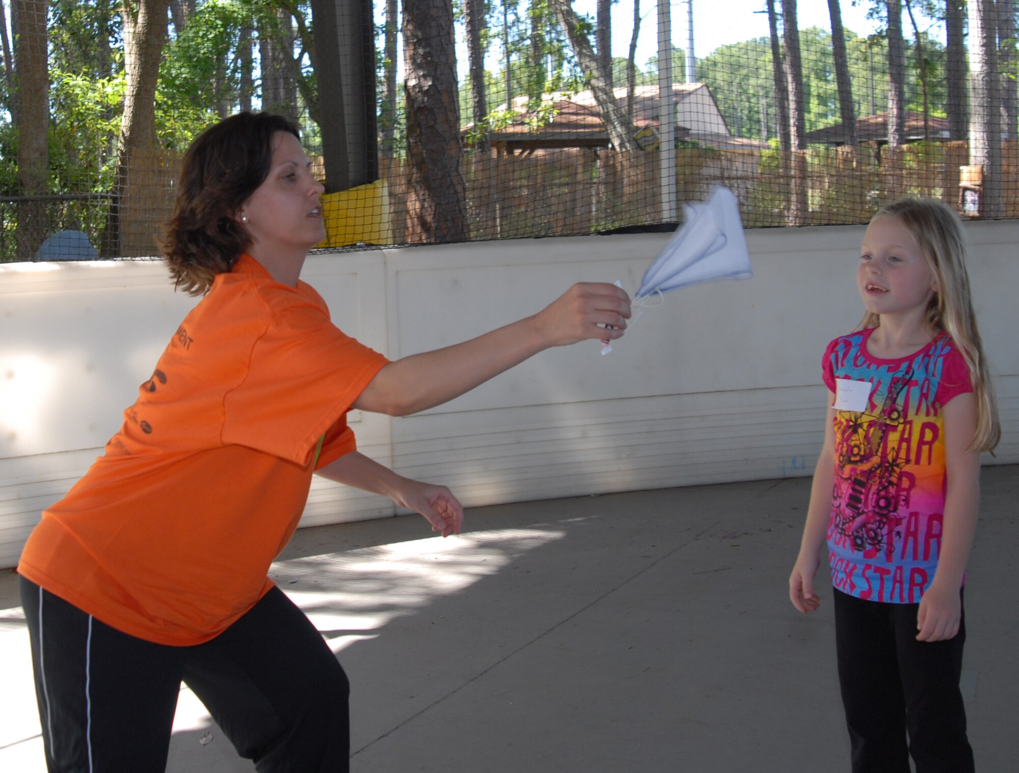 Master Sgt. Jennifer Diaz and Alexandra Manion, daughter of Lt. Col. Lisa Manion, 623rd Air and Space Operations Center, get ready to throw a "chocolate" parachute in the air during the Military Child Education Coalition's "Tell Me a Story" program hosted by the Airman & Family Readiness Center's School Liaison Program at Hurlburt Field, April 25. The reading of "Mercedes and the Chocolate Pilot" was scheduled as part of the base's events for the Month of the Military Child. (DoD photo by U. S. Air Force Staff Sgt. Orly N. Tyrell/Released)