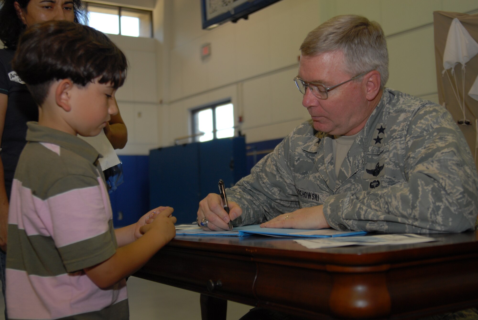 Maj. Gen. Kurt Cichowski, Air Force Special Operations Command vice commander, signs a copy of the book "Mercedes and the Chocolate Pilot" for Luca Maberry, son of Senior Master Sgt. Jeffery Maberry, AFSOC, during the Military Child Education Coalition's "Tell Me a Story" program hosted by the Airman & Family Readiness Center's School Liaison Program at Hurlburt Field, April 25. The book reading was scheduled as part of the base's events for the Month of the Military Child. (DoD photo by U. S. Air Force Staff Sgt. Orly N. Tyrell/Released)