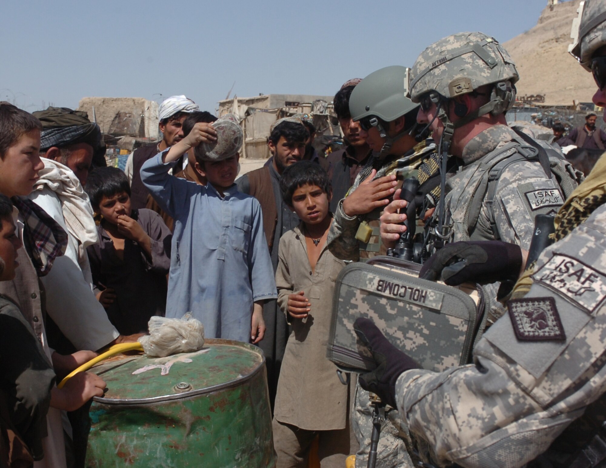 Sgt. Eric Holcomb, 1st Lt. Addison Taylor and their interpreter interact with young shepherds tending animals in the Qalat City Bazaar on April 29, 2010. The Soldiers, members of the Arkansas Agriculture Development Team in Zabul, Afghanistan, visited the bazaar to discuss farming issues and locate stores that supply farming materials and equipment. The 188th Fighter Wing deployed three unit members with the ADT, including Maintenance Squadron commander, Lt. Col. David Sheely, who is the team leader for the ADT's agricultural specialists. (U.S. Air Force photo by Lt. Col. Keith Moore/Arkansas National Guard Public Affairs)