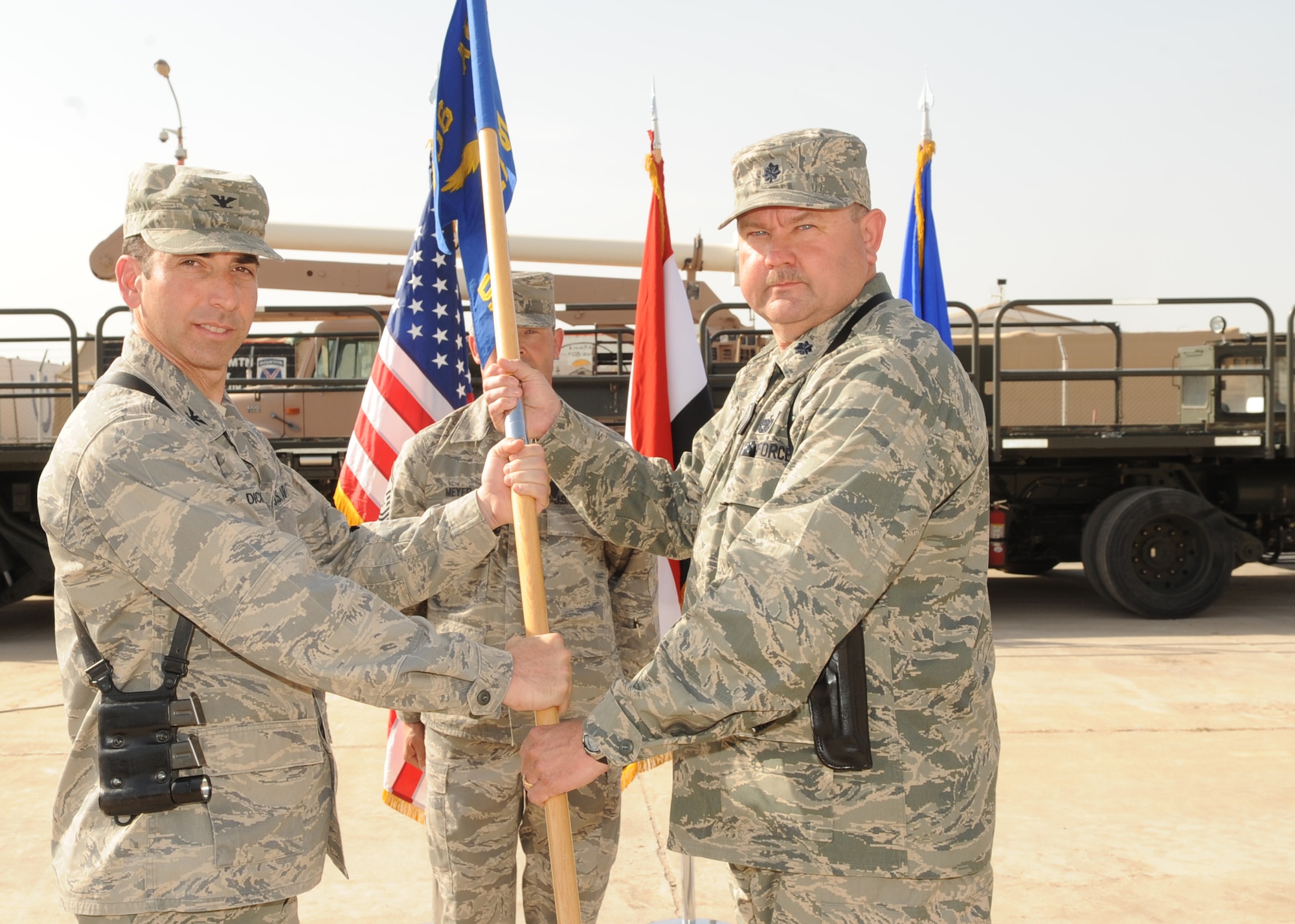 WRIGHT-PATTERSON AIR FORCE BASE, Ohio - Col. Leonard Dick, 506th Air Expeditionary Group commander, passes a guidon to Lt. Col. Joseph Savage, incoming 506th Expeditionary Logistics Readiness Squadron commander, during the 506 ELRS change of command ceremony at Kirkuk Regional Air Base, Iraq, April 21. Colonel Savage is currently deployed from the 445th Logistics Readiness Squadron. (Courtesy photo) 