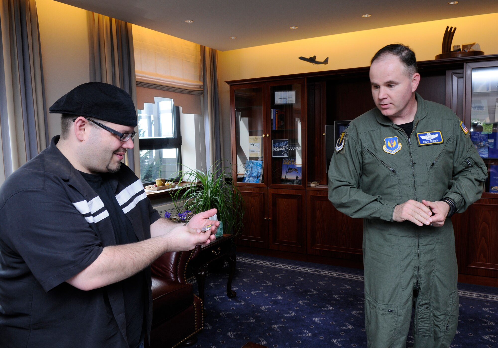 Mason Mastroianni, artist of B.C. comic strip, receives a coin from U.S. Air Force Col. Douglas Sevier, 86th Airlift Wing vice commander, Ramstein Air Base, Germany, April 29, 2010. Mr. Mastronianni is one of 9 professional cartoonist from the National Cartoonist Society that visited various areas on Ramstein as part of a morale tour in cooperation with the United Service Organizations. (U.S. Air Force photo by Airman 1st Class Brittany Perry)