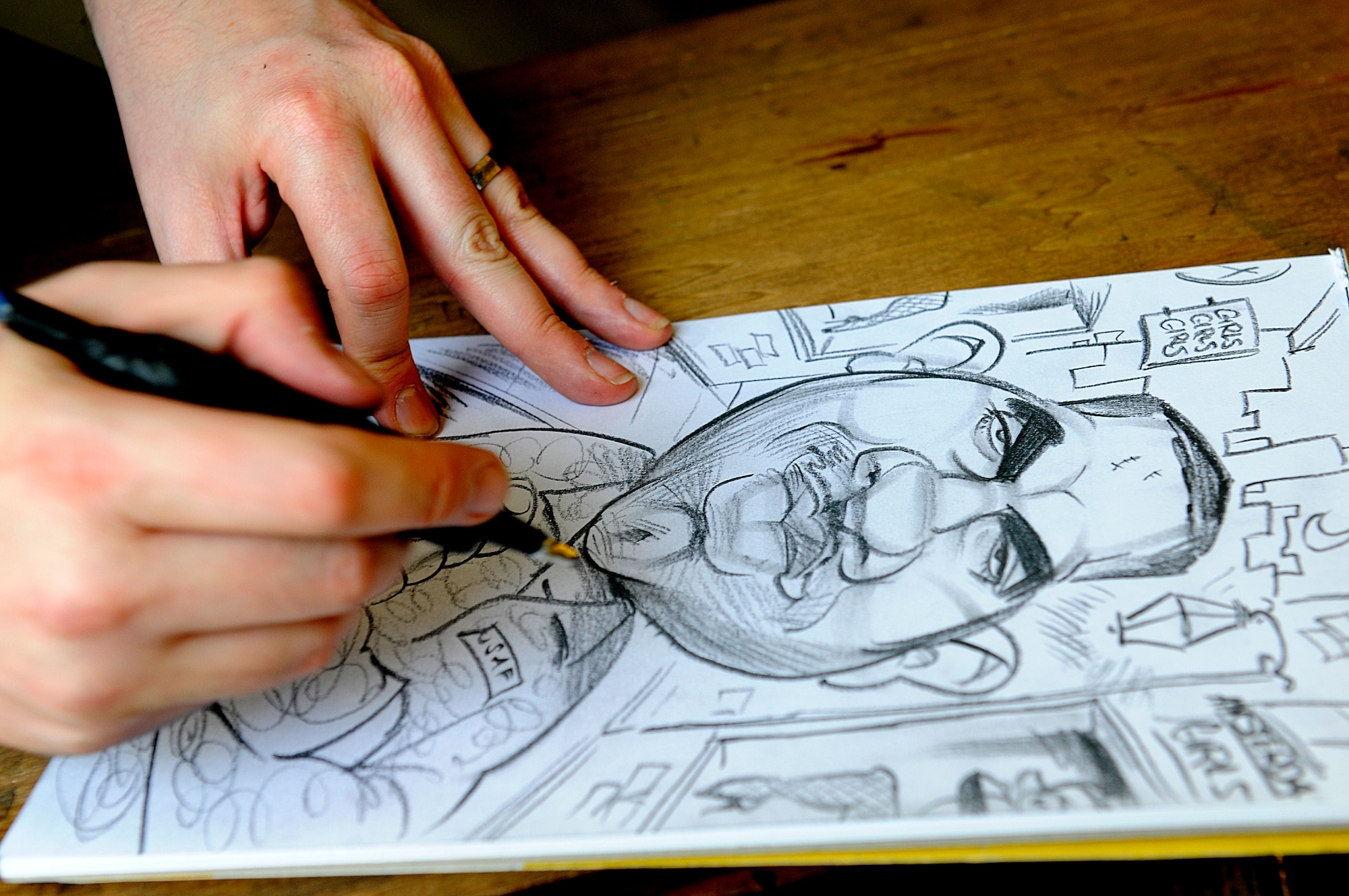 Mr. Ed Steckley, MAD magazine artist for DC comics, adds the finishing touches to a drawing of U.S. Air Force Staff. Sgt. Shawn Walters, 86th Maintenance Squadron aircraft metal technician, Ramstein Air Base, Germany, April 29, 2010. Several cartoonists took part in a two-day tour of the Kaiserslautern Military Community, visiting with wounded warriors, military members and their families. (U.S. Air Force photo by Airman 1st Class Brea Miller)