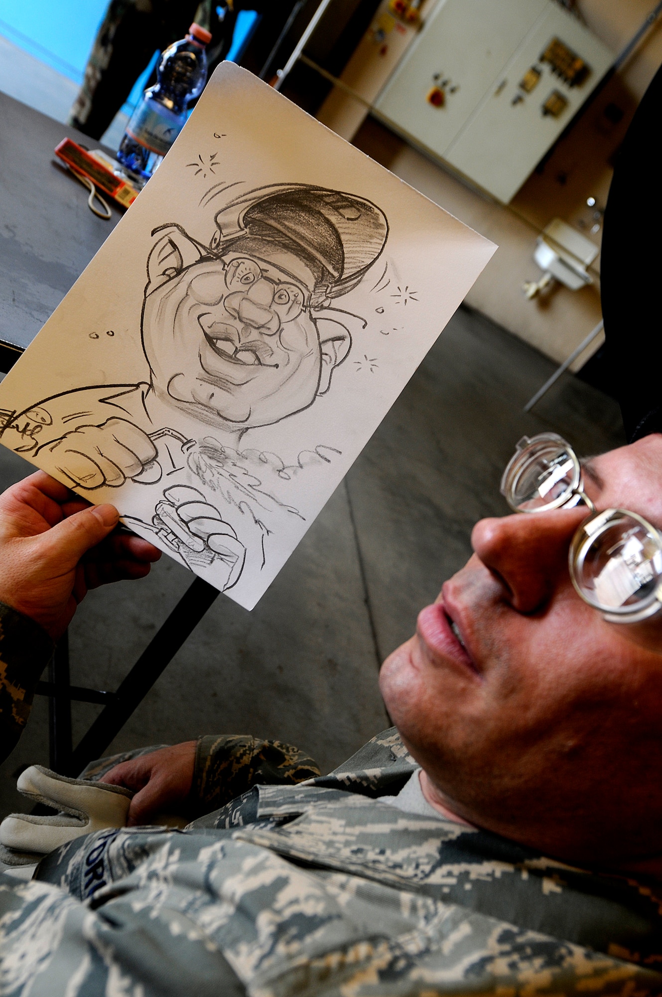 U.S. Air Force Tech. Sgt. Jim Gifasi, 86th Maintenance Squadron aircraft metal technician, poses with a drawing of himself, Ramstein Air Base, Germany, April 29, 2010. Several cartoonists took part in a two-day tour of the Kaiserslautern Military Community, visiting with wounded warriors, military members and their families. (U.S. Air Force photo by Airman 1st Class Brea Miller)