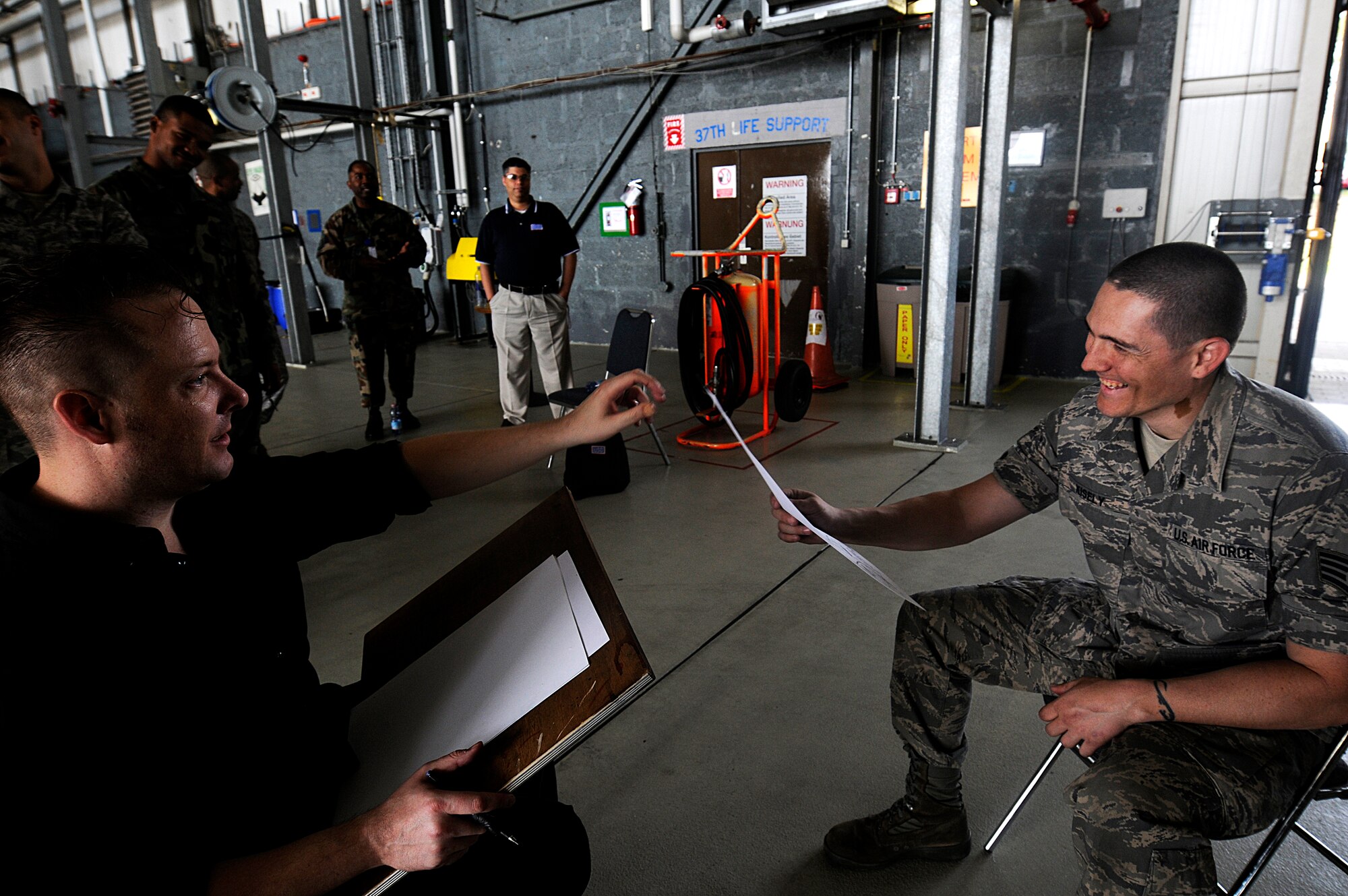 Mr. Ed Steckley, MAD magazine artist for DC comics, amuses U.S. Air Force Staff Sgt. Brian Kisley, 86th Operation Support Squadron crew chief, with a sketch of him, Ramstein Air Base, Germany, April 29, 2010. Several cartoonists took part in a two-day tour of the Kaiserslautern military community, visiting with wounded warriors, military members and their families. (U.S. Air Force photo by Airman 1st Class Brea Miller)