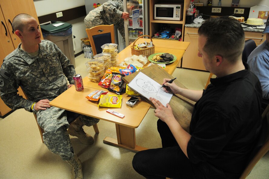 U.S. Army Sgt. Jonathan Tilk, 561st Regional Support Group, poses while cartoonist Ed Steckley sketches his caricature portrait at the United Services Organization in the Contingency Aeromedical Staging Facility, Ramstein Air Base, Germany, April 28, 2010. Several cartoonists took part in a two-day tour of the Kaiserslautern Military Community, visiting with wounded warriors, military members and their families. (U.S. Air Force photo by Airman 1st Class Desiree Esposito)