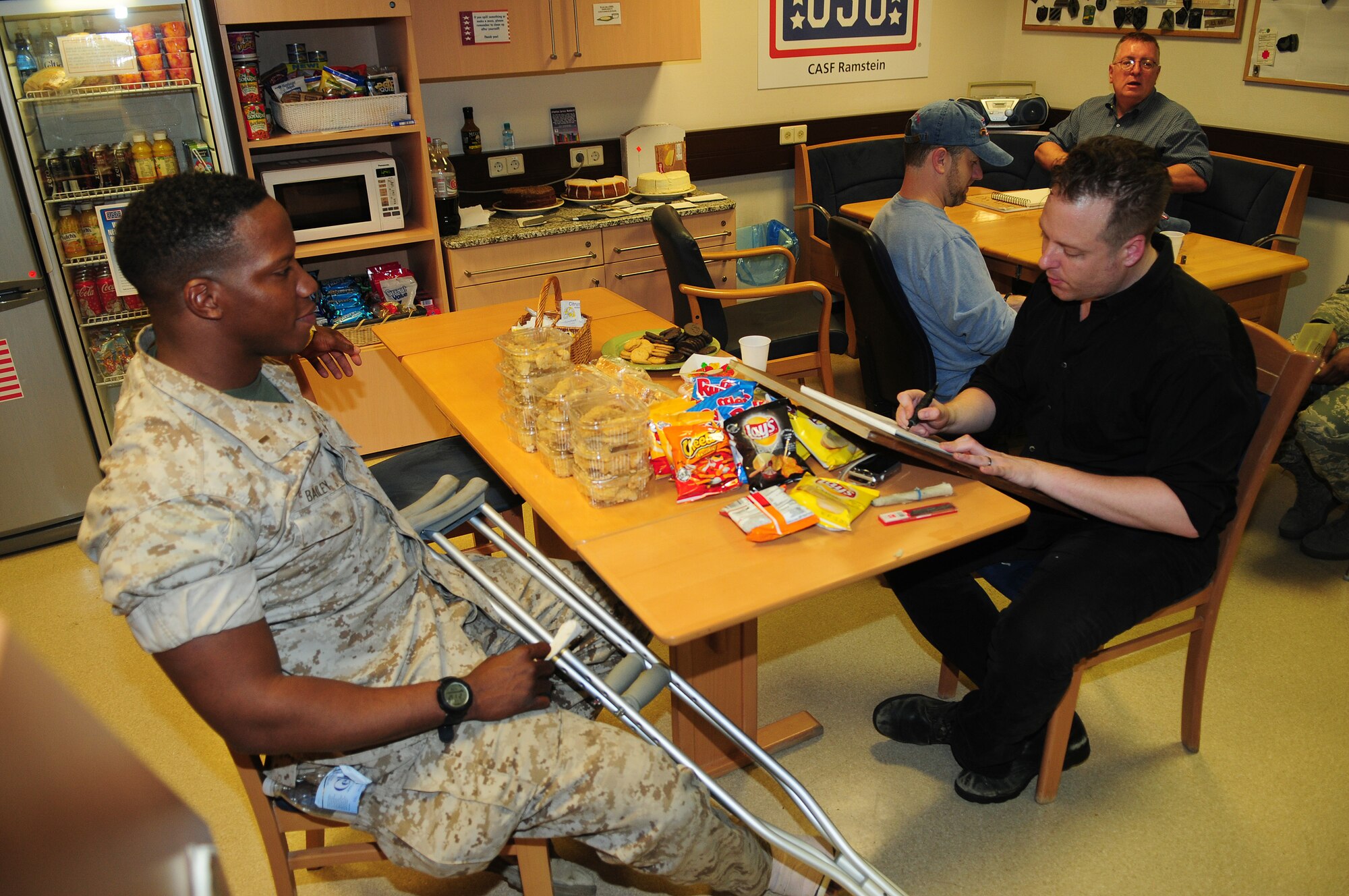 U.S. Marine Corps 1st Lt. Robert Bailey II, 1st Battalion, 2nd Marine Regimen, Camp Lejeune, N.C., poses while cartoonist Ed Steckley sketches his caricature portrait at the United Services Organization during a visit at the Contingency Aeromedical Staging Facility, Ramstein Air Base, Germany, April 28, 2010. Several cartoonists took part in a two-day tour of the Kaiserslautern Military Community, visiting with wounded warriors, military members and their families. (U.S. Air Force photo by Airman 1st Class Desiree Esposito)