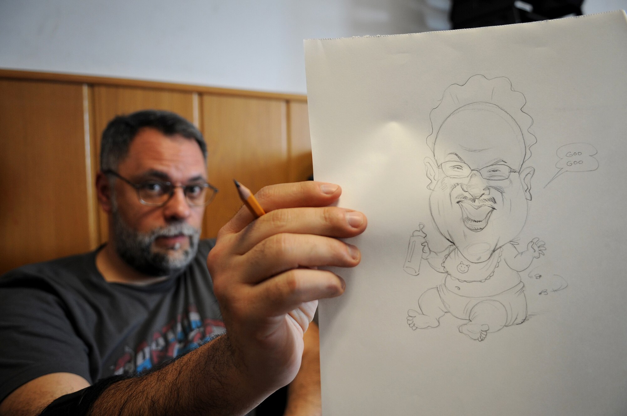 Ray Alma, Mad Magazine cartoonist, showcases one of his drawings during a United Service Organizations tour, Ramstein Air Base, Germany, April 29, 2010. Ray started drawing while in elementary school and does freelance drawings in New York City, N.Y. Several cartoonist took part in a two-day tour of the Kaiserslatuern Military Community, visiting with wounded warriors, military members and their families. (U.S. Air Force photo by Airman 1st Class Grovert Fuentes-Contreras)