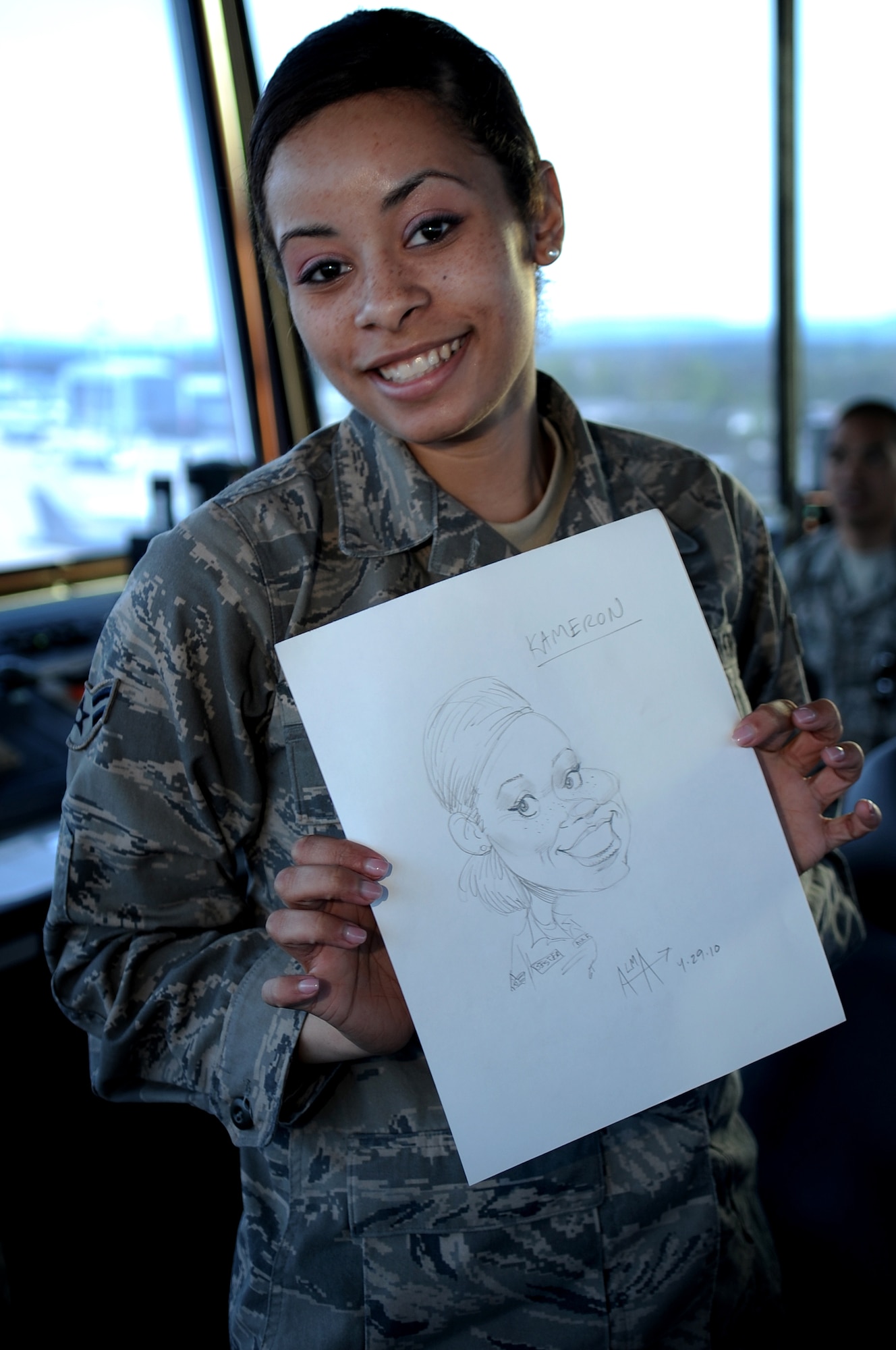 U.S. Air Force Airman 1st Class Kameron Bester, 86th Operations Support Squadron air traffic controller, showcases a portrait of herself drawn by Ray Alma, Mad Magazine cartoonist, during a United Service Organizations tour, Ramstein Air Base, Germany, April 29, 2010. Several cartoonist took part in a two-day tour of the Kaiserslatuern Military Community, visiting with wounded warriors, military members and their families. (U.S. Air Force photo by Airman 1st Class Grovert Fuentes-Contreras)