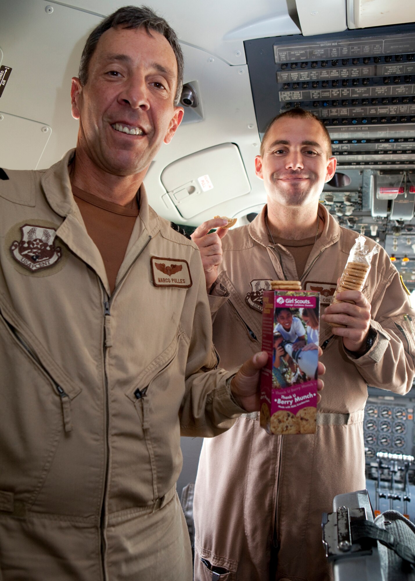Recently the hearts of deployed 380th Air Expeditionary Wing Airmen at an undisclosed location in Southwest Asia were warmed when they received a sweet gesture from California Girl Scouts in the form of 1,800 boxes of Girl Scout Cookies. Junior Troop #361 in Vacaville, Calif. sent the cookies which have made their way all over base. These two air crew members from the 908th Expeditionary Air Refueling Squadron pose with their favorite, Berry Munch, on the flight deck of KC-10 Extender aircraft where he serves as an aircrew member. (U.S. Air Force photo/Staff Sgt. Leonel Gallardo/released)