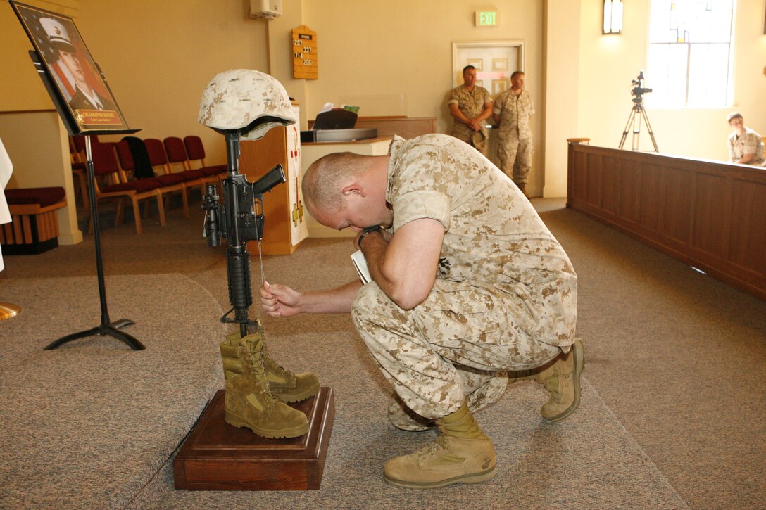 A Marine pays his final respects at the Marine Memorial Chapel, April 30, for Cpl. Samantha L. Schultz, motor transport operator, Motor Transport Company, Combat Logistics Battalion 5, Combat Logistics Regiment 1, 1st Marine Logistics Group, who died of injuries from an off-duty-vehicle accident, April 24. Fellow service members, family and friends gathered at the chapel to mourn and celebrate Schultz’s life.