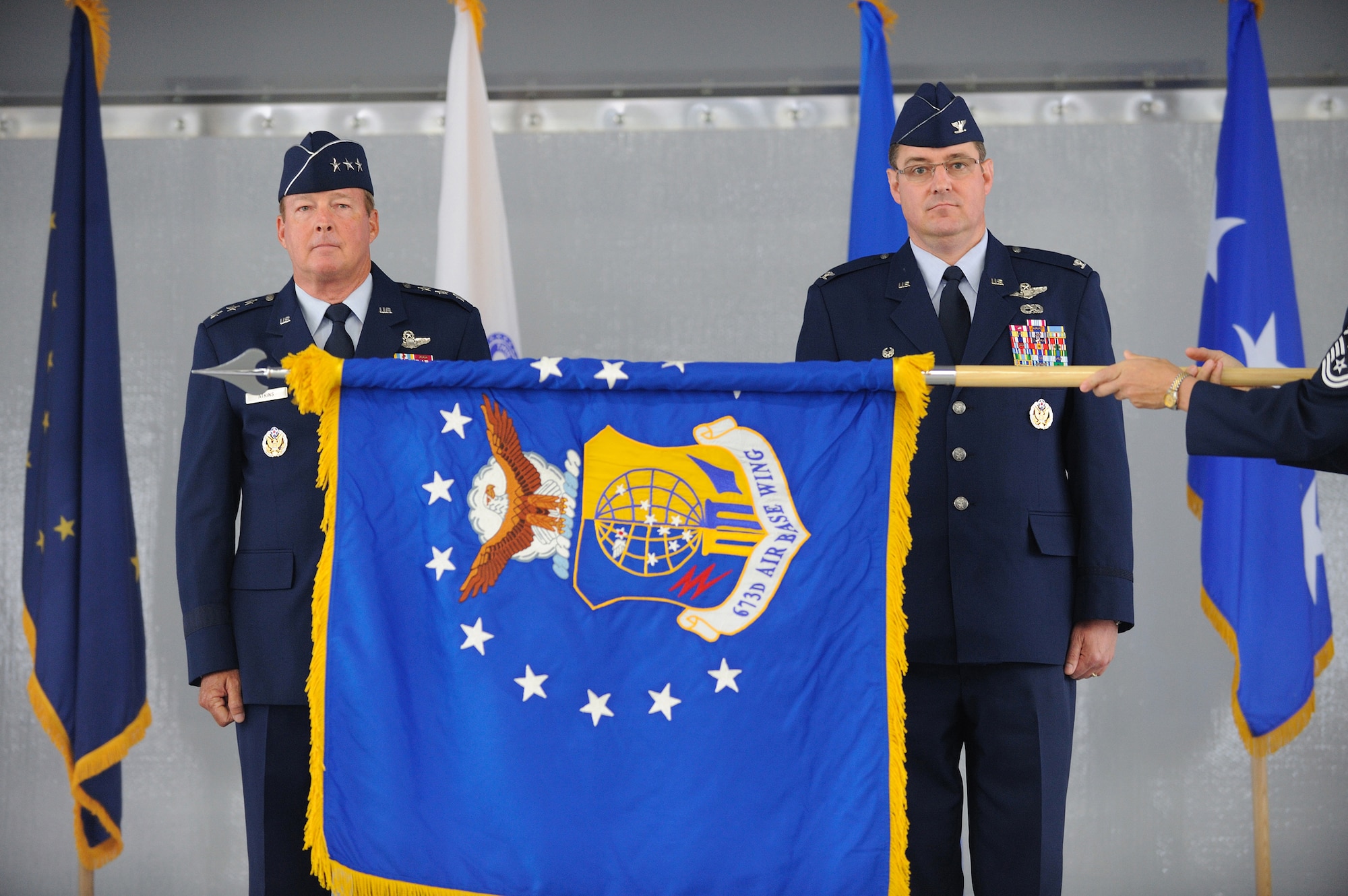 JOINT BASE ELMENDORF-RICHARDSON, Alaska -- Lt .Gen. Dana  T. Atkins, commander Alaskan Command, and Col. Robert D. Evans, commander 673d Air Base Wing, stand-by as the 673d Air Base Wing (673d ABW) guidon is unfurled during the unit's activation ceremony July 30. The 673d ABW is the supporting unit for Joint Base Elmendorf-Richardson which is comprised of over 6,000 military, civilian and contractors from both Elmendorf Air Force Base and Fort Richardson Army Garrison near Anchorage, Alaska. (Air Force photo by Master Sgt. Jeremiah Erickson)