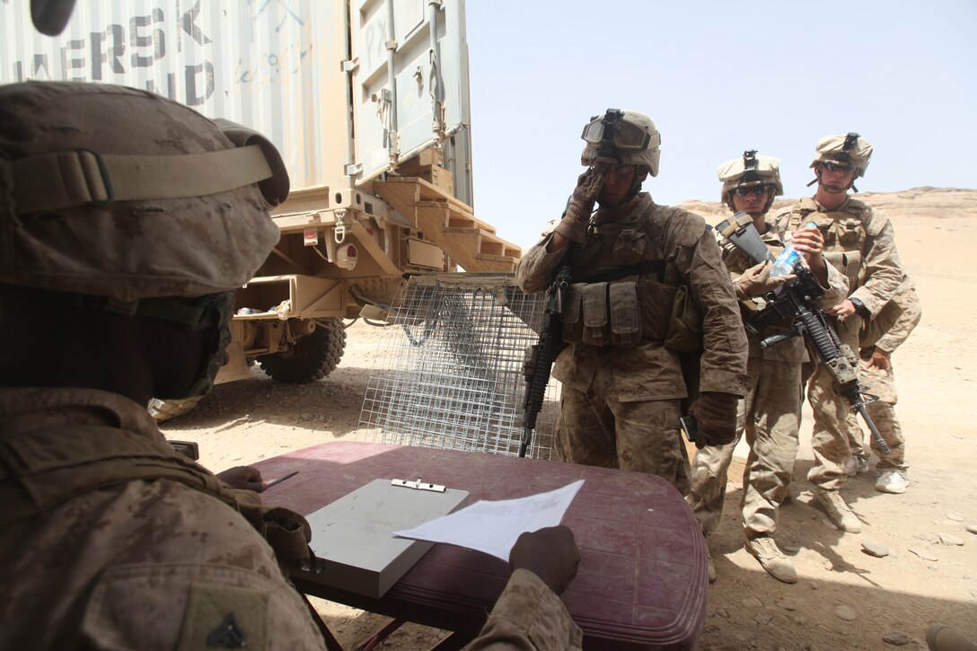 Outside of their combat outpost, Marines line up dressed in their flak jackets and Kevlar helmets to take some cash out from a disburser during a Warrior Express Services Team mission in northern Helmand Province, July 16-30. A WES Team consists of a disburser and Marine Corps Community Services specialists. Their mission is to bring services not readily available on these remote forward operating bases and combat outposts to service members conducting missions there, such as a ‘mobile ATM’ and a mobile Post Exchange.