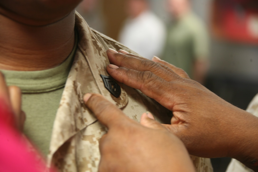 Jerry C. Bennett, a retired master gunnery sergeant, pins his son’s gunnery sergeant chevrons on his collar during a promotion ceremony for the Bennett twins at Marine Air Control Group 28, Aug. 2. Terence and Terrell Bennett, identical twins, were promoted to gunnery sergeant on the same day. Terrell is the intelligence chief for MACG-28 at Marine Corps Air Station Cherry Point and Terence is an ammunition technician for Weapons Training Battalion, Quantico, Va.