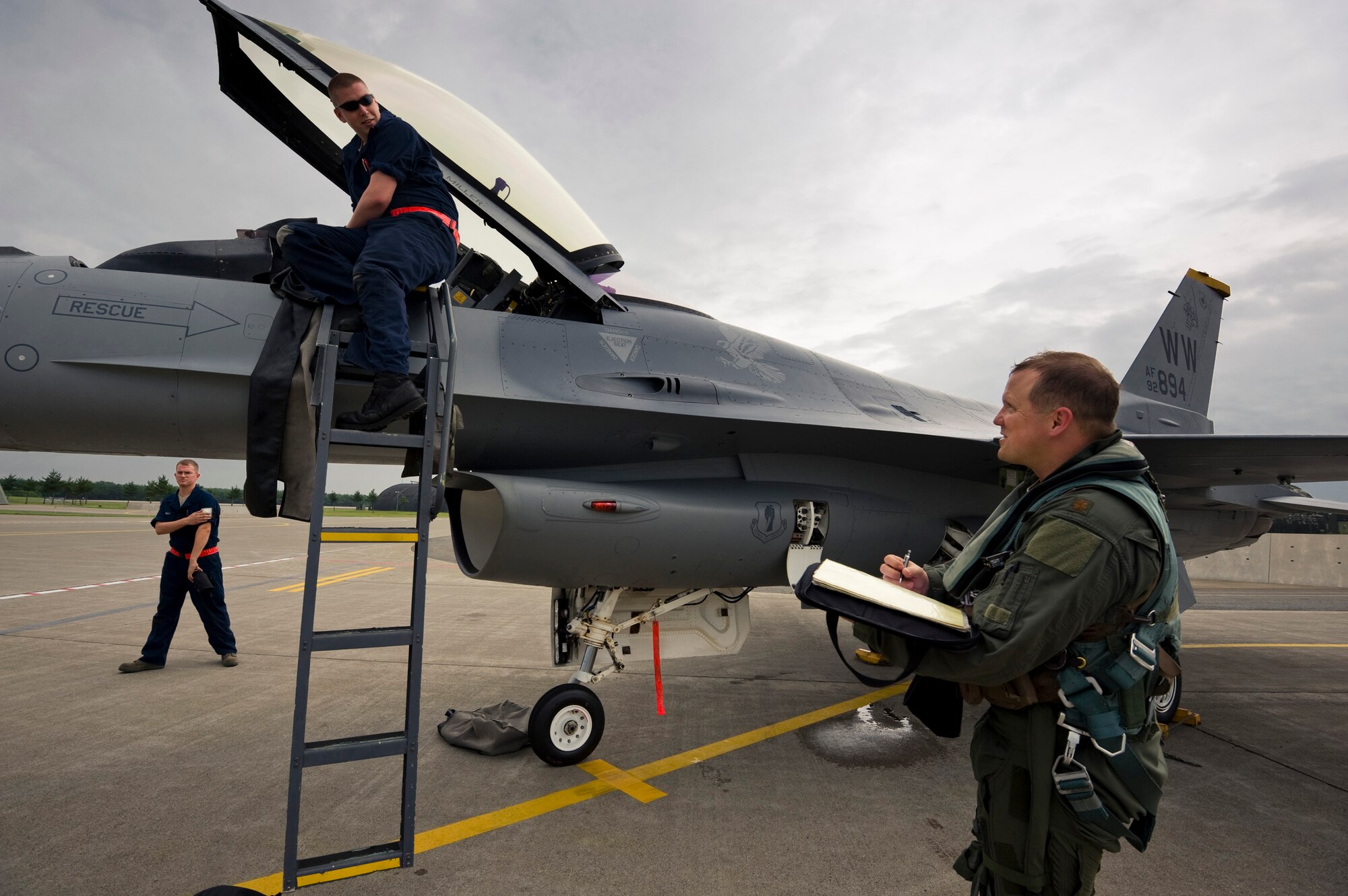 MISAWA AIR BASE, Japan -- Maj. John Greven, 13th Air Force Detachment 1, A5 plans and exercises officer, asks Airman 1st Class Patric Shaw, 13th Aircraft Maintenance Unit crewchief, about local policies regarding paperwork following a training sortie Aug. 2. This was Major Greven's first flight at Misawa Air Base. (U.S. Air Force photo/Staff Sgt. Samuel Morse)