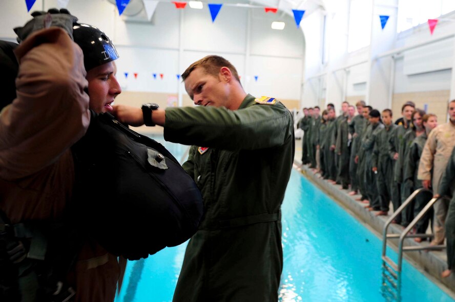 ELLSWORTH AIR FORCE BASE S.D. – (Left) Senior Airman Zachary Yoakam, 28th Operations Group survival, evasion, resistance and escape specialist and Staff Sgt. Brandon Dunphy, 28th OG SERE NCO in-charge prepare to demonstrate SERE water survival training during a base tour, July 30. The importance of the training is to ensure all Airmen who perform duties around water are properly trained on how to survive during an emergency.  (U.S. Air Force photo/Airman 1st Class Corey Hook)