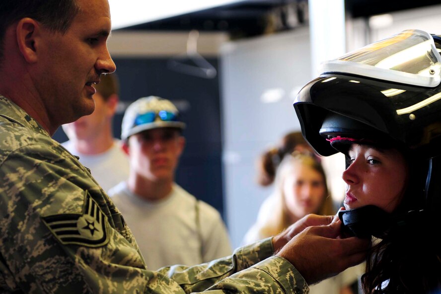ELLSWORTH AIR FORCE BASE S.D. – Staff Sgt. Darryl Wilcken, 28th Civil Engineer Squadron explosion ordinance disposal craftsman, assists a Junior Reserve Officers’ Training Corps member, with putting on a bomb suit helmet during a base tour, July 30. As part of the tour, the EOD flight showcased the equipment used during missions. (U.S. Air Force photo/Airman 1st Class Corey Hook)