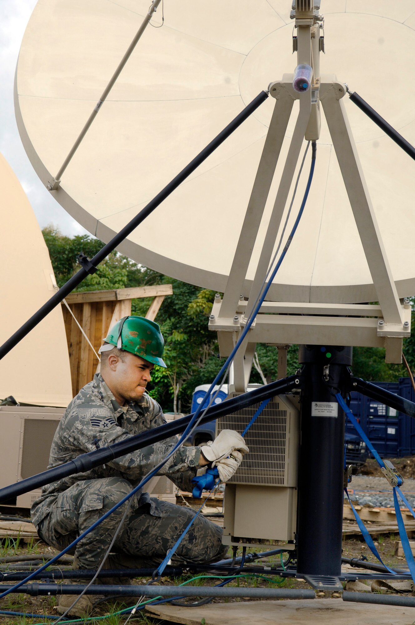 Senior Airman Cesar Morales secures the base of the satellite array July 28, 2010, during Exercise New Horizons Panama 2010. Airman Morales is deployed from the 32nd Combat Communications Squadron. (U.S. Air Force photo/Tech. Sgt. Eric Petosky)