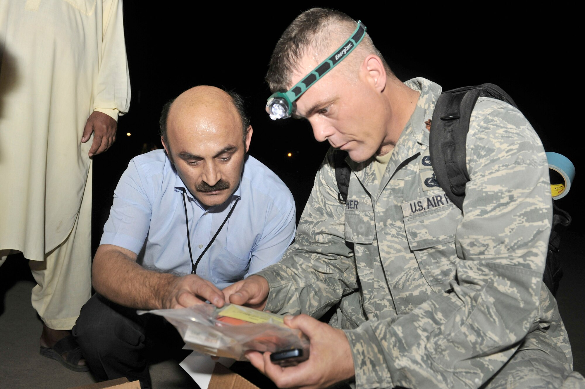 Maj. James Swisher shows Hassan Zulfiquar  the contents of a Halal meal July  31, 2010, in Peshawar, Pakistan. The meals were delivered by a C-130H Hercules assigned to the 455th Air Expeditionary Wing from Bagram Airfield, Afghanistan. Mr. Zulfiguar is the Director of National Disaster Management Authority for Pakistan and Major Swisher is a representative of the Office of Defense Representative of Pakistan. (U.S. Air Force photo/Staff Sgt. Christopher Boitz)