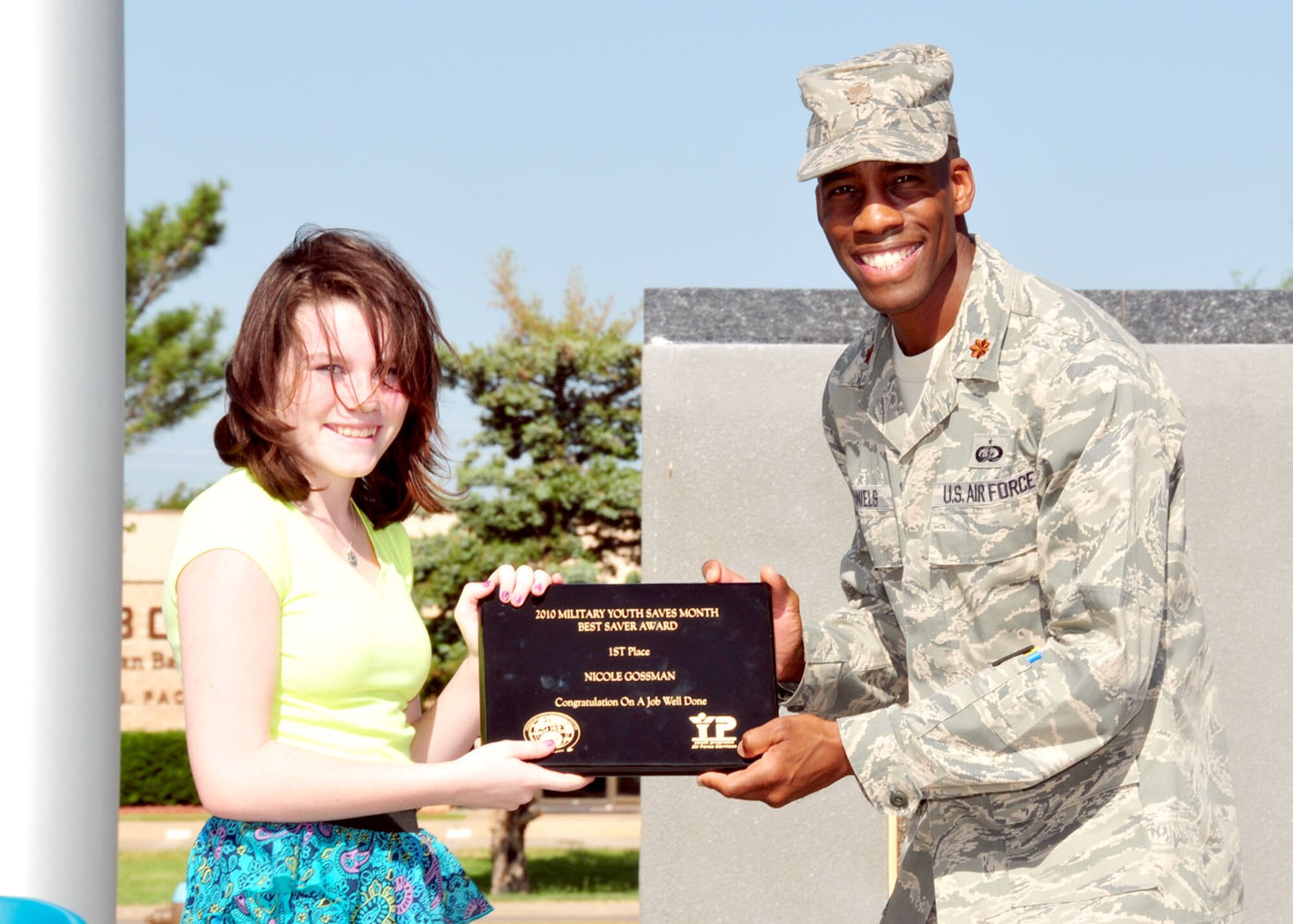 ALTUS AIR FORCE BASE, Okla.-- Miss Nicole Gossman (left) poses with Maj. Calvin Daniels, 97th Force Support Squadron commander (right) as the top "super saver" following the end of Military Youth Saves month at the Altus Air Force Base Wings of Freedom Park July 30.  The month long program encouraged military youth to learn the benefits of saving throughout the month of July and culminated with an award ceremony for the top savers and a short speech about the benefits of starting on the road to financial freedom early in life.  (U.S. Air Force photo by Master Sgt. Brian Boisvert/Released 97th Air Mobility Wing / Public Affairs)