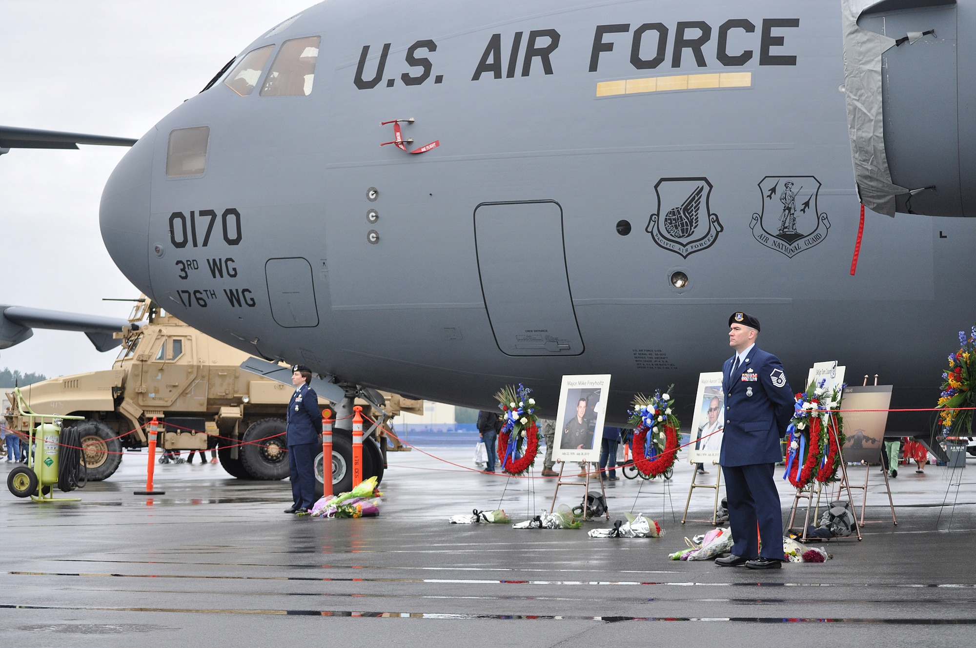 Master Sgt. Brian Johnson (right) and 2nd Lt. Sherry Ferno, both of the 176th Security Forces Squadron, stand guard at the memorial display for Sitka 43 during the Arctic Thunder air show Saturday, July 31, at Joint Base Elmendorf-Richardson. Four aviators were killed when Sitka 43, a C-17, crashed Wednesday, July 28, while practicing for the air show. (Army photo by John Pennell/JBER PAO)