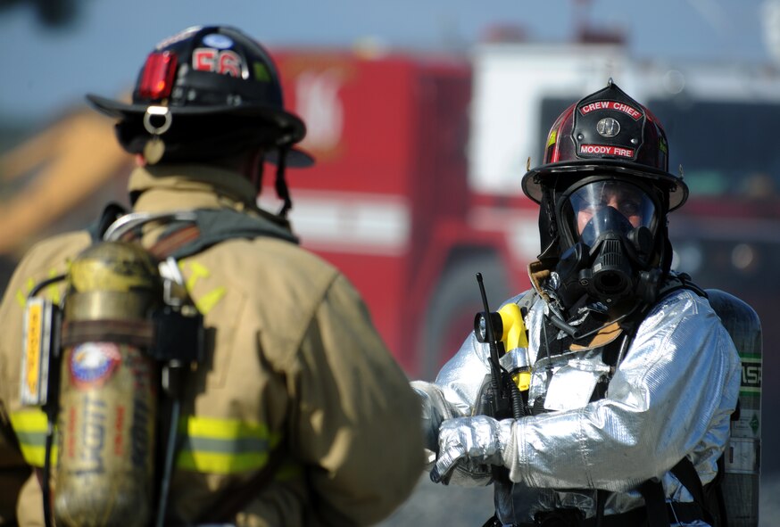 MOODY AIR FORCE BASE, Ga. -- Dave Laplante, 23rd Civil Engineer Squadron fire emergency services flight crew chief, finishes donning his gear prior to the start of a live fire training exercise as a firefighter from the Valdosta Fire Department gets into place here July 27. Mr. Laplante was the safety officer and his job was to ensure all personnel took the proper safety precautions throughout the training. (U.S. Air Force photo by Airman 1st Class Benjamin Wiseman/RELEASED)