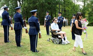 LANGLEY AIR FORCE BASE, Va. – U.S. Army Lt. Col. (ret.) Earl Gentile and his wife Julie walk between members of the Langley Honor Guard after the commencement of the ground breaking ceremony July 31. The Disabled Veterans Committee on Housing helps disabled veterans receive grants up to $63,780 from the Department of Veterans Affairs to build, purchase or remodel their homes. (U.S. Air Force photo/ Senior Airman Gul Crockett)