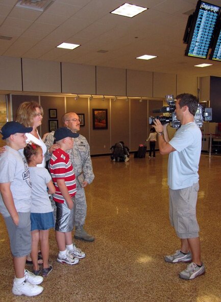 Senior Master Sgt. Jeffrey Mansfield and his family are interviewed by a local television reporter at the Salt Lake International Airport Saturday. Sergeant Mansfield and about 30 civil engineers from the 419th Fighter Wing set out for a six-month deployment to Afghanistan where they will service and construct facilities at Bagram Airfield and several forward operating bases and combat outposts. (U.S. Air Force photo/Kari Tilton)