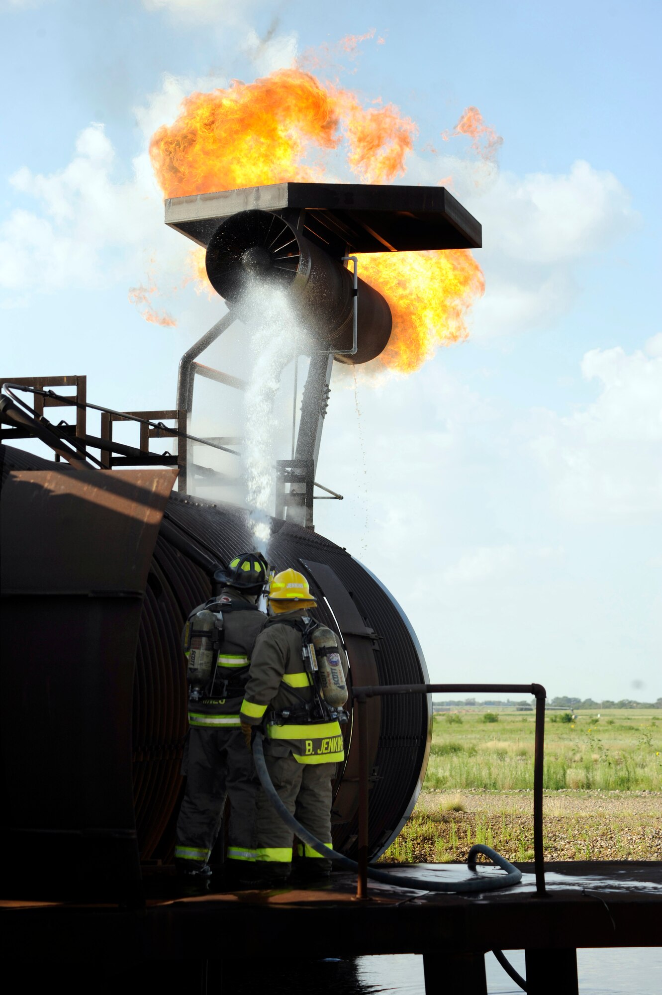 Firefighters from Clovis, N.M., extinguish a propane-fueled fire on a mock aircraft during training at Cannon Air Force Base, N.M., July 26, 2010. Town firefighters worked with the base to meet annual training requirements for aircraft blazes. (U.S. Air Force photo by Greg Allen) (RELEASED)