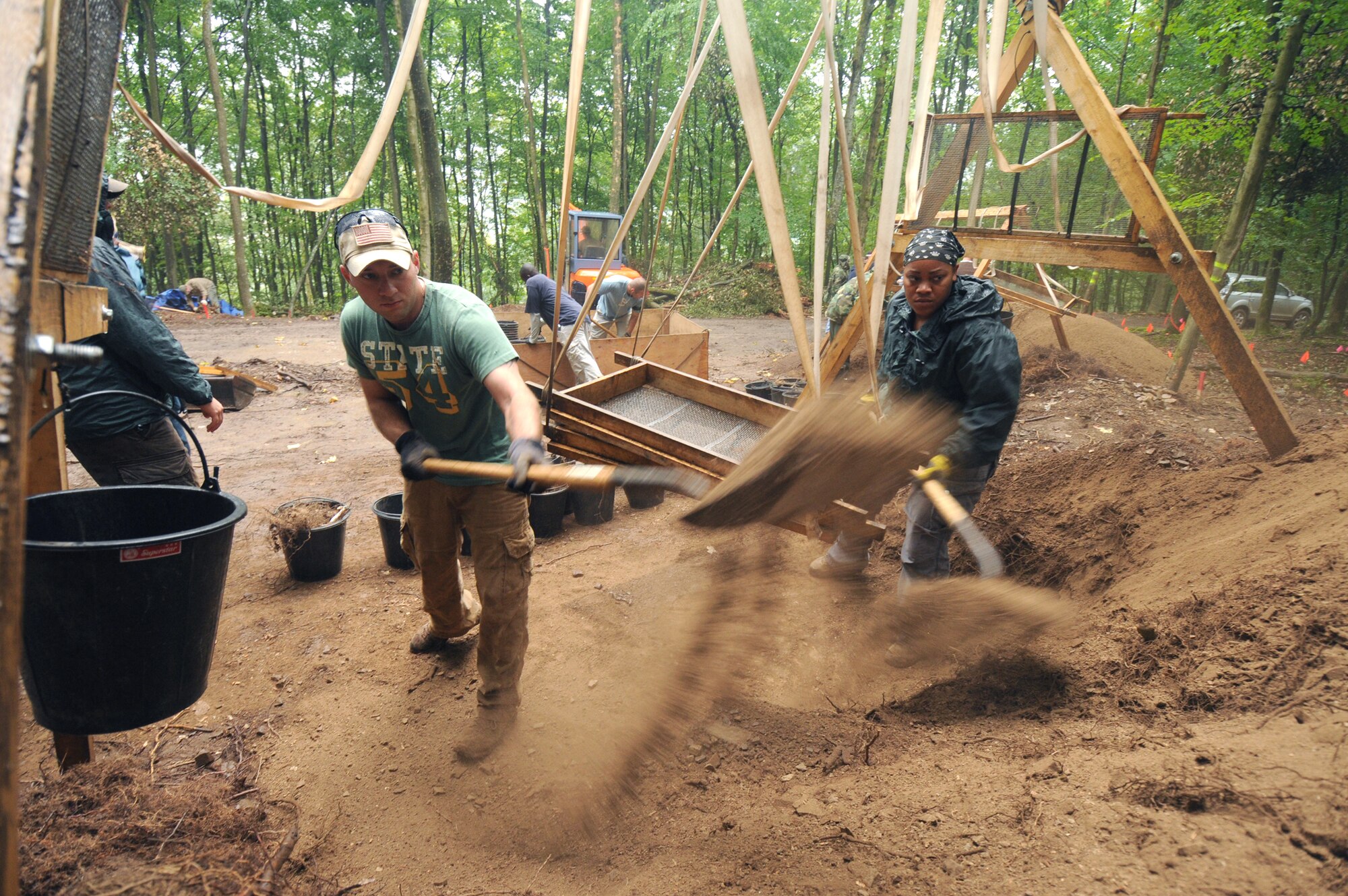 Army Staff Sgt. Ryszard Tella (left) and Staff Sgt. Alceve Lawrence shovel dirt from a sifting station during the last day of digging during their mission July 28, 2010, in Rheinland-Pfalz, Germany. The mission of the JPAC is to achieve the fullest possible accounting of all Americans missing as a result of the nation's past conflicts. Sergeants Tella and Lawrence are assigned to the Joint Prisoners of War/Missing in Action Accounting Command. (U.S. Air Force photo/Staff Sgt. Benjamin Wilson)