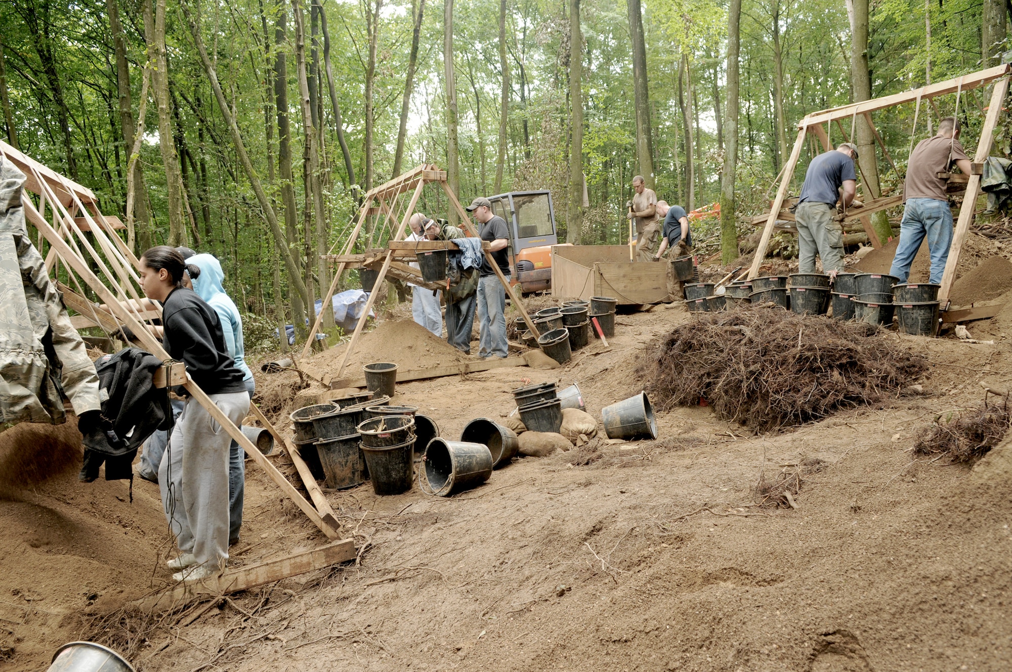 Servicemembers sift through dirt on a local logging trail in search of wreckage from an aircraft downed during World War II during a Joint Prisoners of War/Missing in Action Accounting Command mission July 28, 2010, in Rheinland-Pfalz, Germany. The mission of the JPAC is to achieve the fullest possible accounting of all Americans missing as a result of the nation's past conflicts. (U.S. Air Force photo/Staff Sgt. Benjamin Wilson)