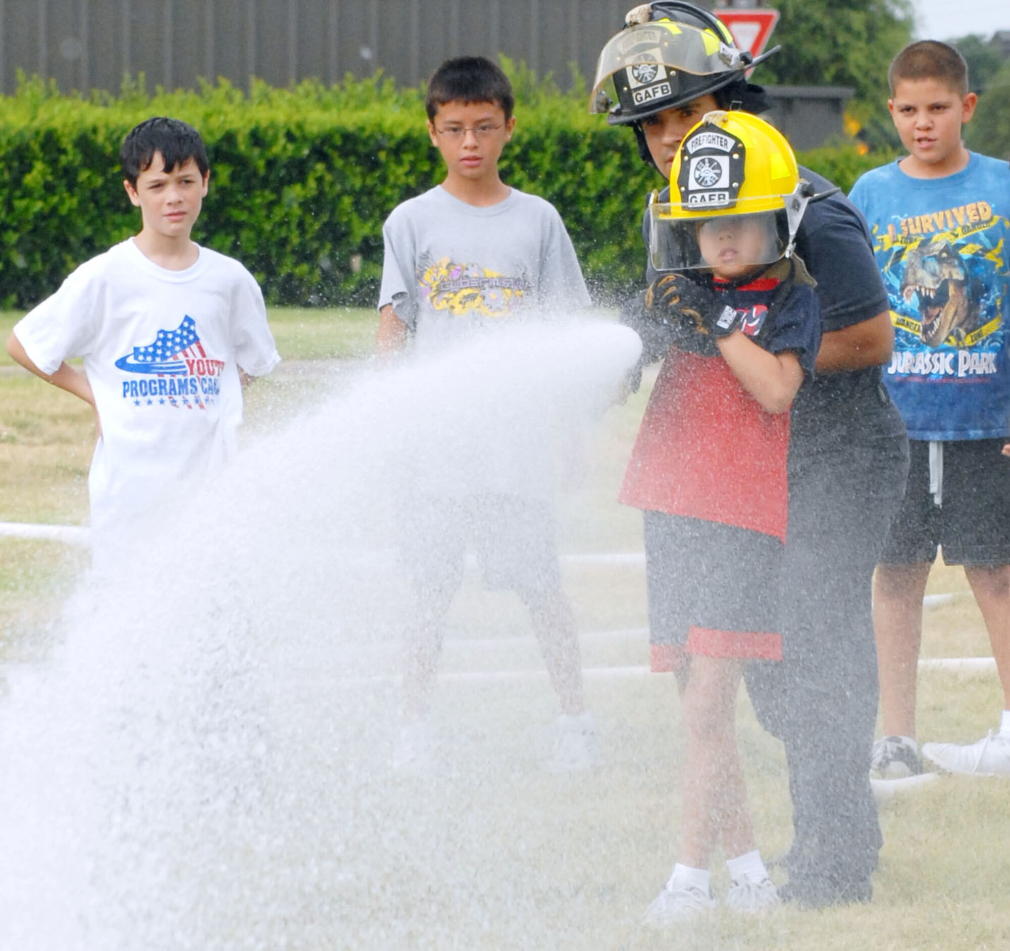 GOODFELLOW AIR FORCE BASE, Texas-- Firefighter shows children how to use a firehose during the Junior Firefighter Camp here July 29. Twelve youths were accepted into the program and taught fire and home safety during the five day camp. (U.S. Air Force photo/Airman 1st Class Jessica D. Keith) 