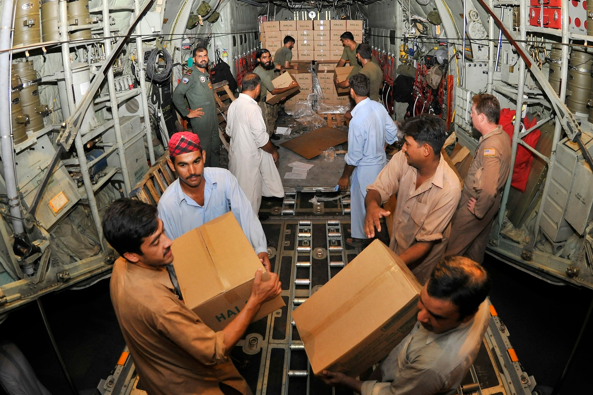Pakistani Air Force members help unload thousands of Halal meals from a U.S. Air Force C-130H at Peshawar, Pakistan, Aug. 1, 2010. The meals will go to Pakistanis affected by the floods that have devastated the region. The C-130H is assigned to the 455th Air Expeditionary Wing at Bagram Airfield, Afghanistan. (U.S. Air Force photo/Staff Sgt. Christopher Boitz)