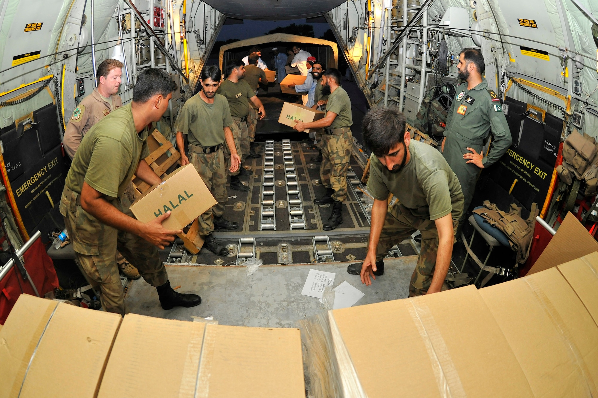 Pakistani Air Force members help unload thousands of Halal meals from a U.S. Air Force C-130H at Peshawar, Pakistan, Aug. 1, 2010. The meals will go to Pakistanis affected by the floods that have devastated the region. The C-130H is assigned to the 455th Air Expeditionary Wing at Bagram Airfield, Afghanistan. (U.S. Air Force photo/Staff Sgt. Christopher Boitz)