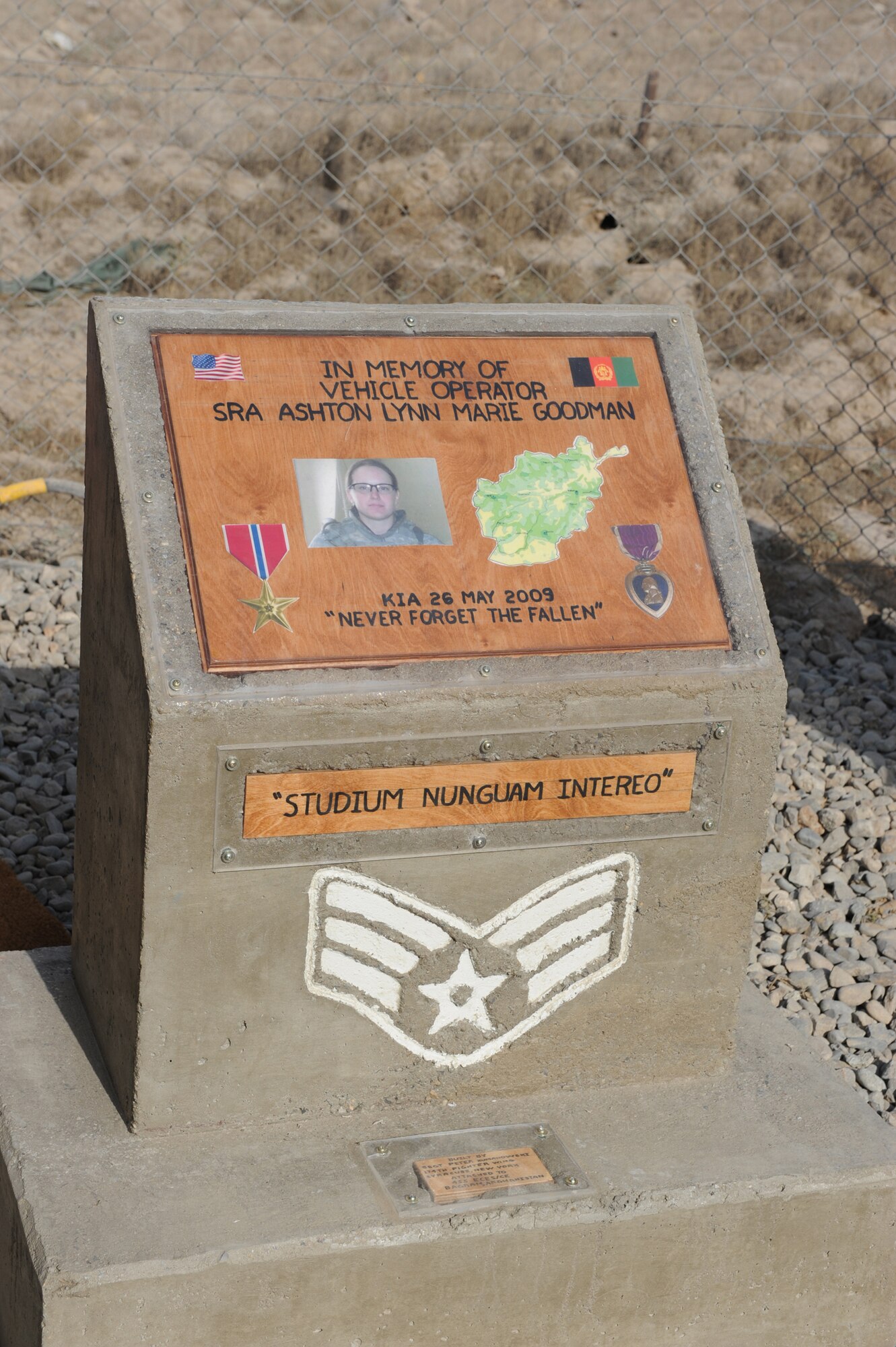 The memorial dedicated on 24 July 2010 by the 455th ELRS to SrA Ashton Lynn Marie Goodman reveals her picture and two of the medals she earned during her career. Emblazoned on its base are the same three Latin words Goodman had tattooed on her arms: Studium Nunquam Intereo?which means ?Spirit never dies.?(U.S. Air Force photo/Maj. John Puckett)