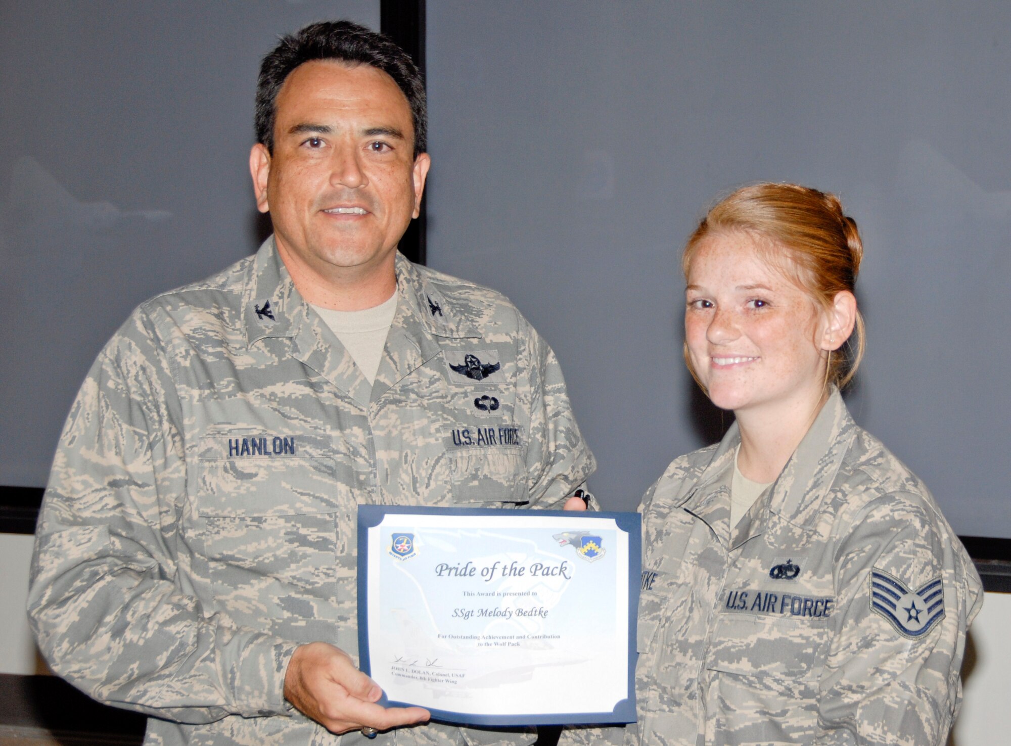KUNSAN AIR BASE, Republic of Korea -- Col. Hugh Hanlon, 8th Fighter Wing vice commander, presents Staff Sgt. Melody Bedtke, 8th Aircraft Maintenance Squadron F-16 dedicated crew chief, with a Pride of the Pack award July 29. (U.S. Air Force photo/Capt. Sheryll Klinkel)