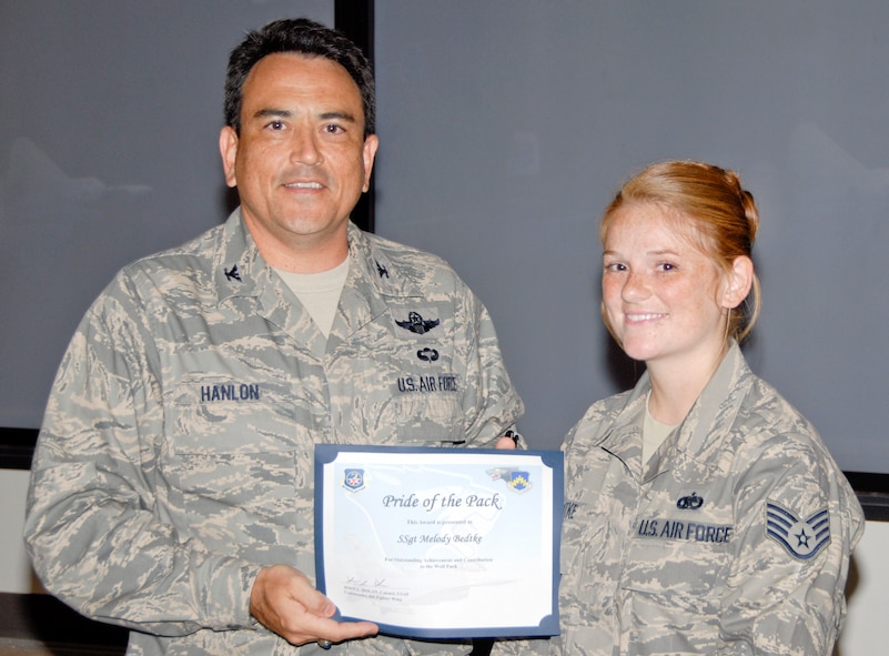 KUNSAN AIR BASE, Republic of Korea -- Col. Hugh Hanlon, 8th Fighter Wing vice commander, presents Staff Sgt. Melody Bedtke, 8th Aircraft Maintenance Squadron F-16 dedicated crew chief, with a Pride of the Pack award July 29. (U.S. Air Force photo/Capt. Sheryll Klinkel)