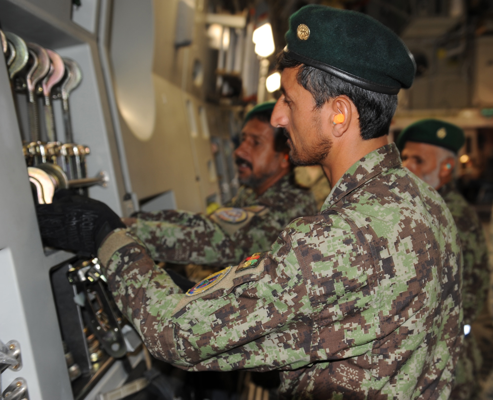 An Afghan aerial porter replaces a tie-down aboard a U.S. Air Force C-17 Globemaster III July 28, 2010 at Bagram Airfield, Afghanistan. (U.S. Air Force photo/Tech. Sgt. Drew Nystrom)
 
